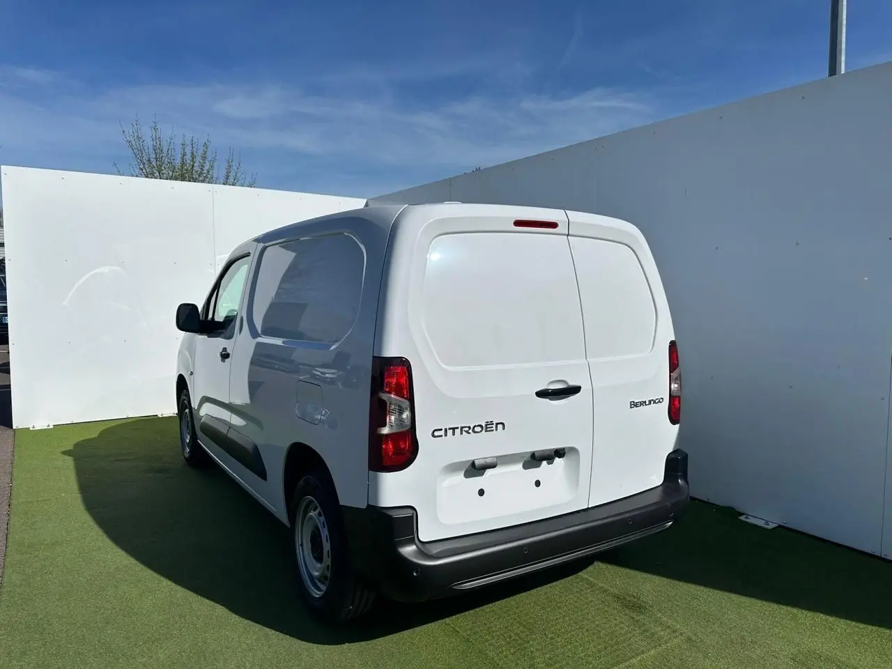 Vue 3/4 arrière droite du Citroën Berlingo blanc Icy version utilitaire avec portes arrière tôlées fermées.