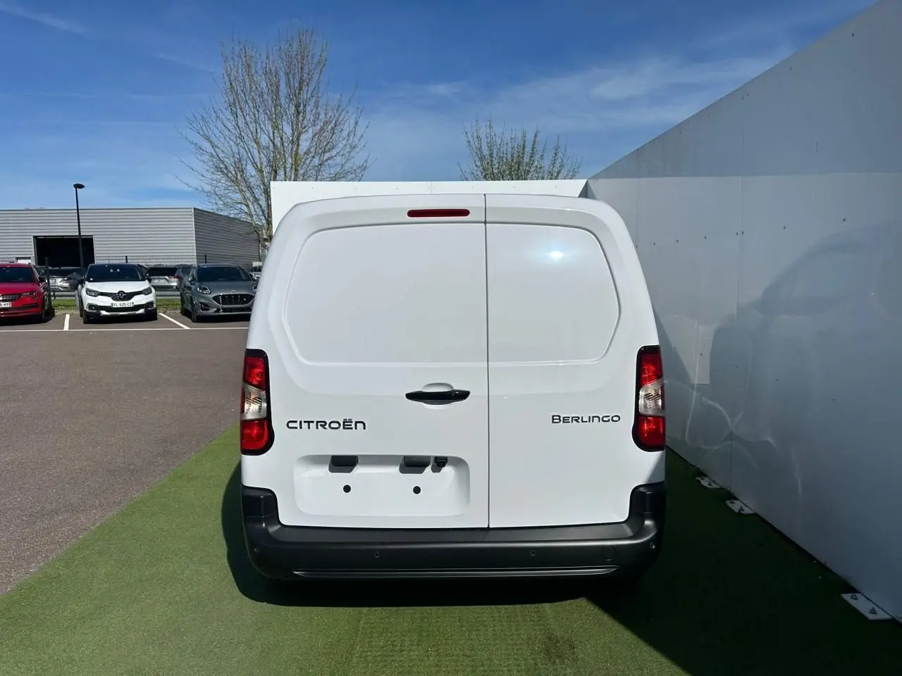 Vue arrière d'un utilitaire Citroën Berlingo blanc Icy avec portes battantes et pare-chocs noir mat.