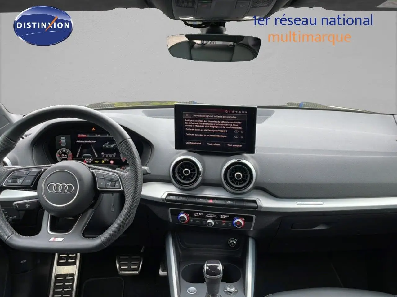 Vue intérieure avant de l'Audi Q2 35 2.0 TDI S-Line 2025 avec tableau de bord noir et écran central tactile.