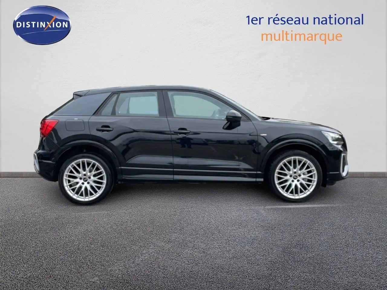 Audi Q2 noir mito metal vue de profil côté gauche, avec jantes alliage 19 pouces et finition S-Line visible.