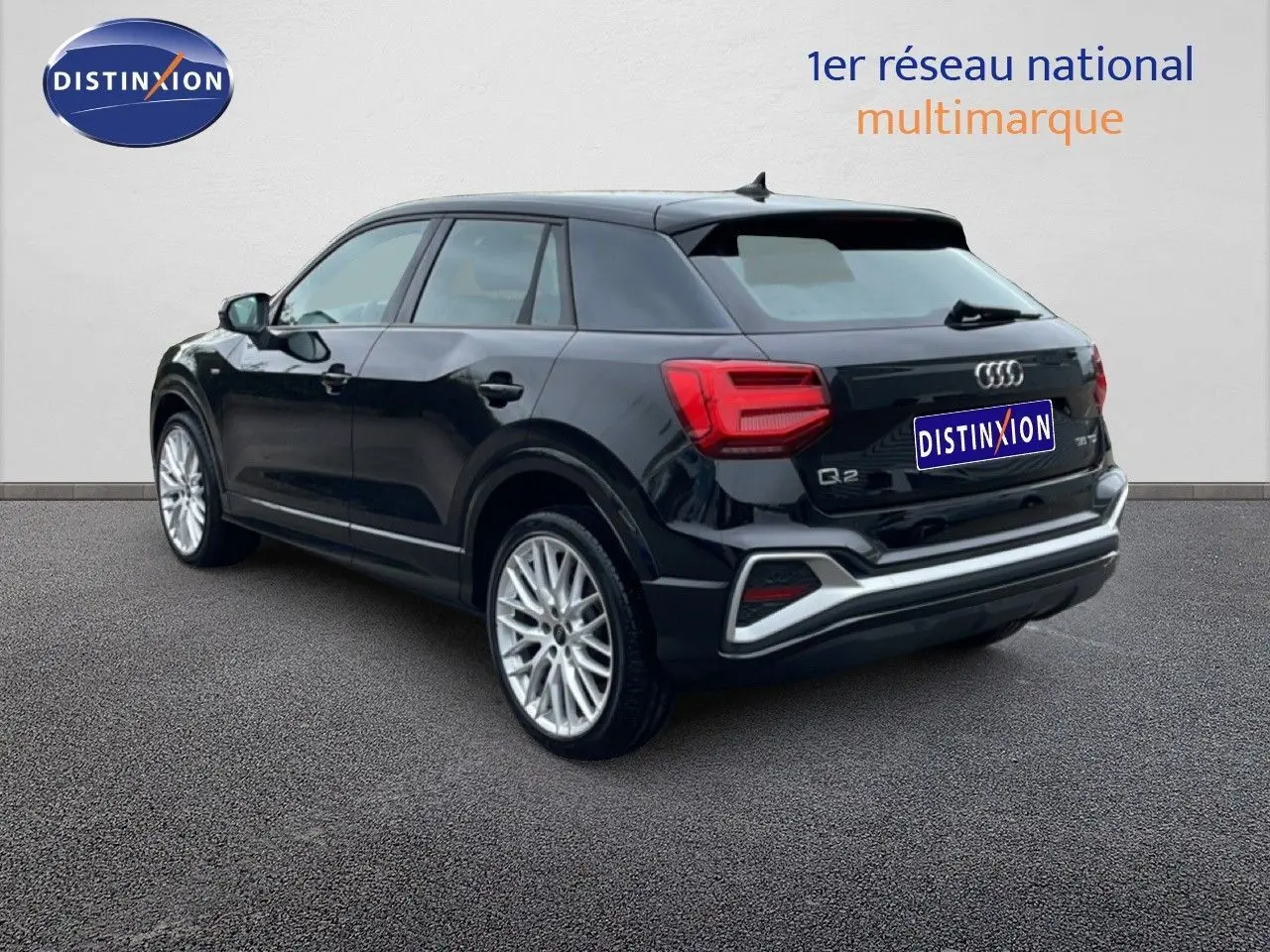 Audi Q2 noir mito métal vue 3/4 arrière droit, avec jantes alliage et feux arrière LED distinctifs.