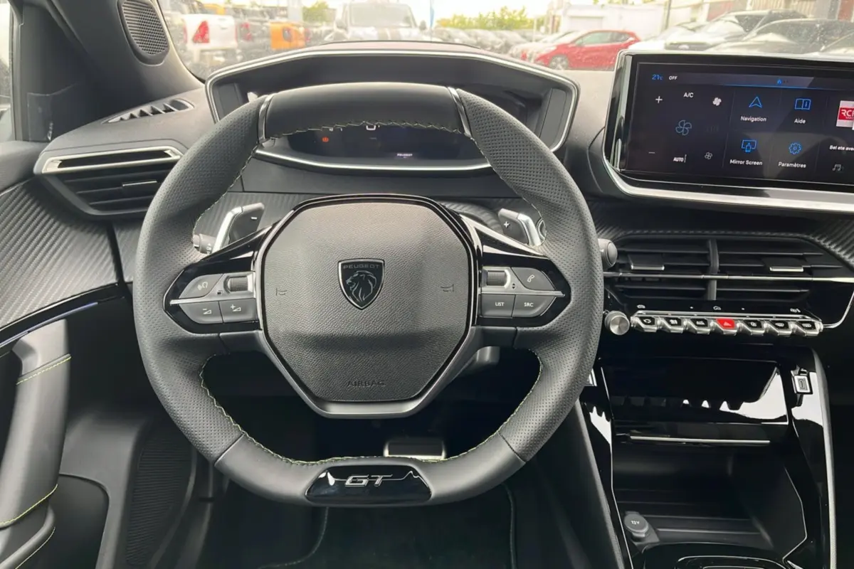 Vue intérieure centrée sur le volant cuir GT et le tableau de bord avec écran tactile du Peugeot 2008 Hybrid 145.