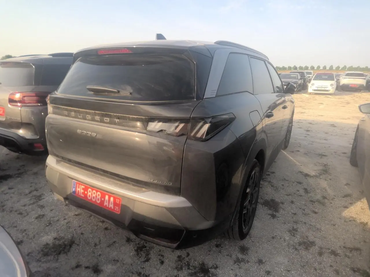 Vue 3/4 arrière droite d’un Peugeot 5008 gris foncé avec vitres teintées et feux arrière LED distinctifs.