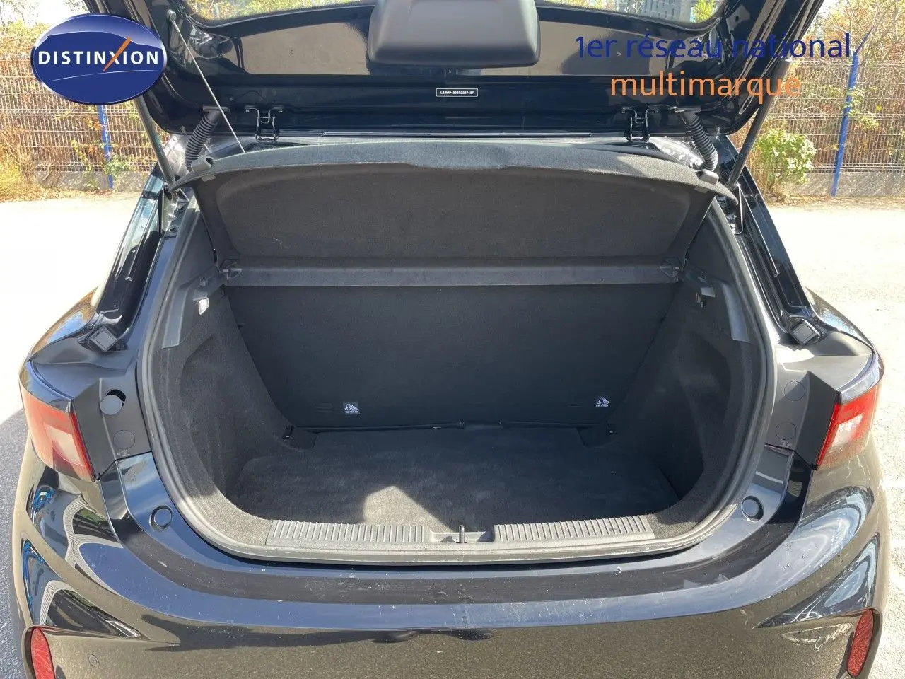 Coffre ouvert vu de l'arrière d'une MG3 1.5L HYBRID+ 195CH Comfort en Pebble Black Metal, montrant l'espace de chargement vide.