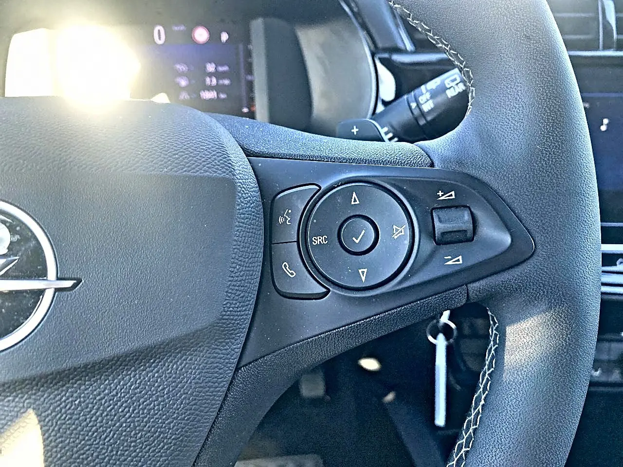 Gros plan sur le volant noir multifonction de l'Opel Corsa 2025 avec commandes audio et téléphone intégrées.