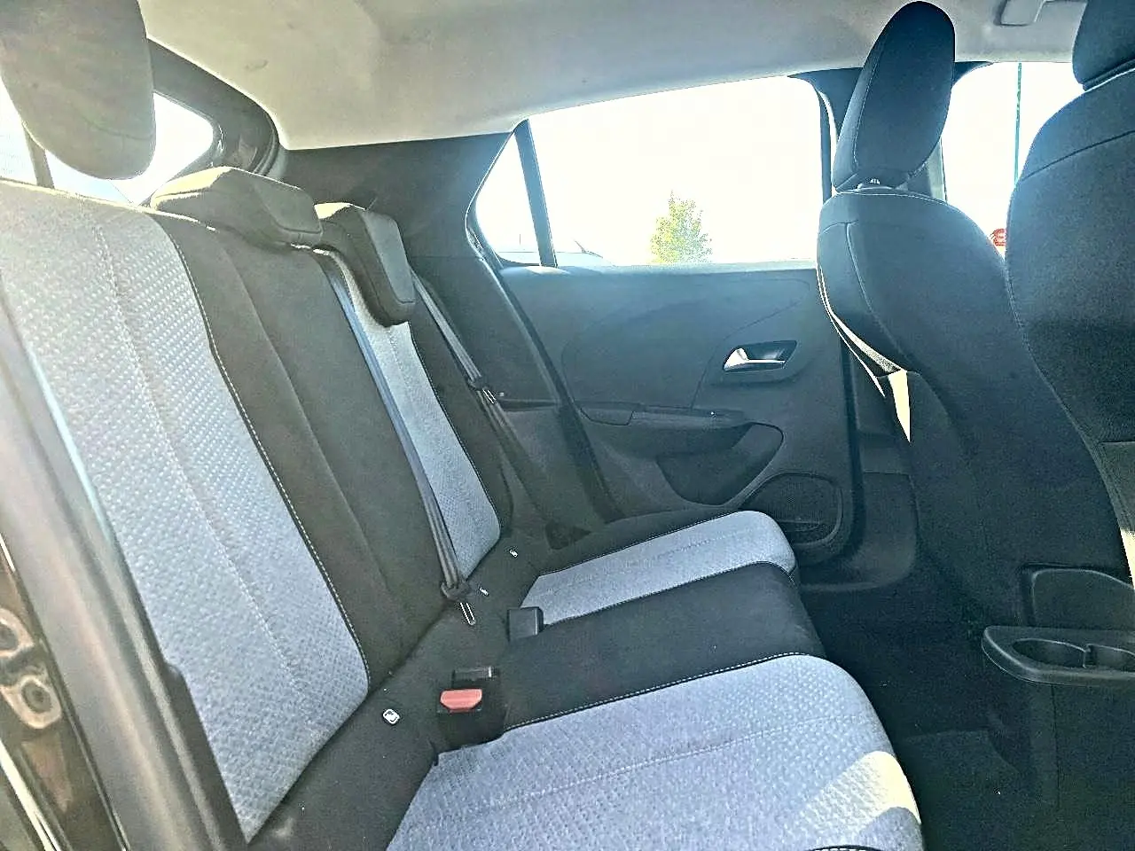 Vue intérieure arrière côté gauche de l’Opel Corsa 2025, sièges tissu bicolore noir et gris, banquette 3 places.