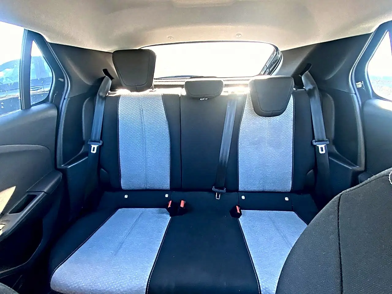 Vue arrière intérieure de la banquette arrière bicolore gris clair et noir de l’Opel Corsa 2025 avec ceintures et appuie-têtes.