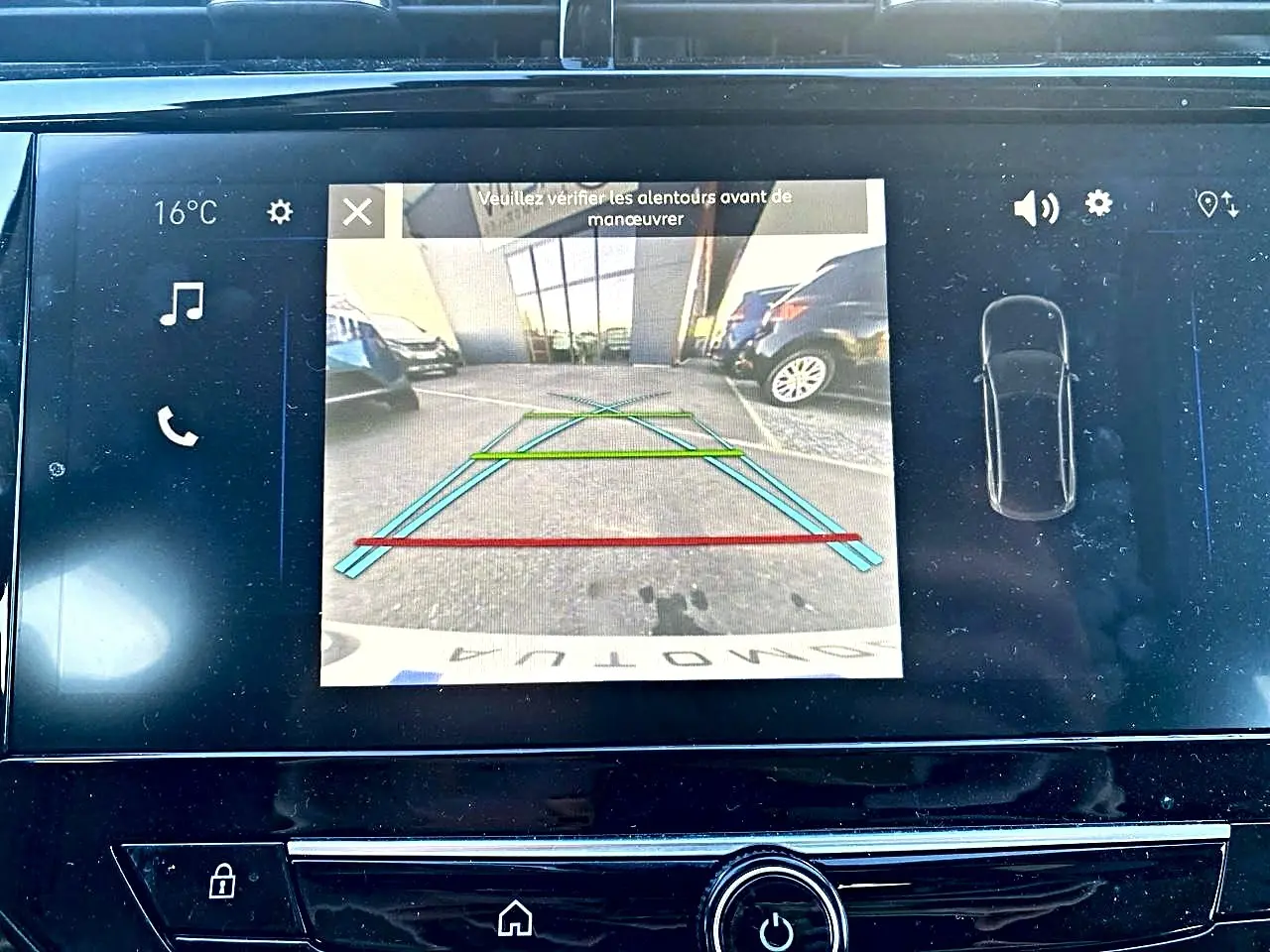 Écran tactile de recul de l’Opel Corsa noire, affichant la caméra arrière avec lignes de guidage colorées.