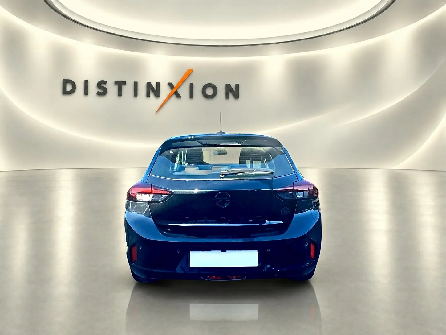 Vue arrière d'une Opel Corsa noire 2025 dans un showroom lumineux avec logo Distinxion en arrière-plan.