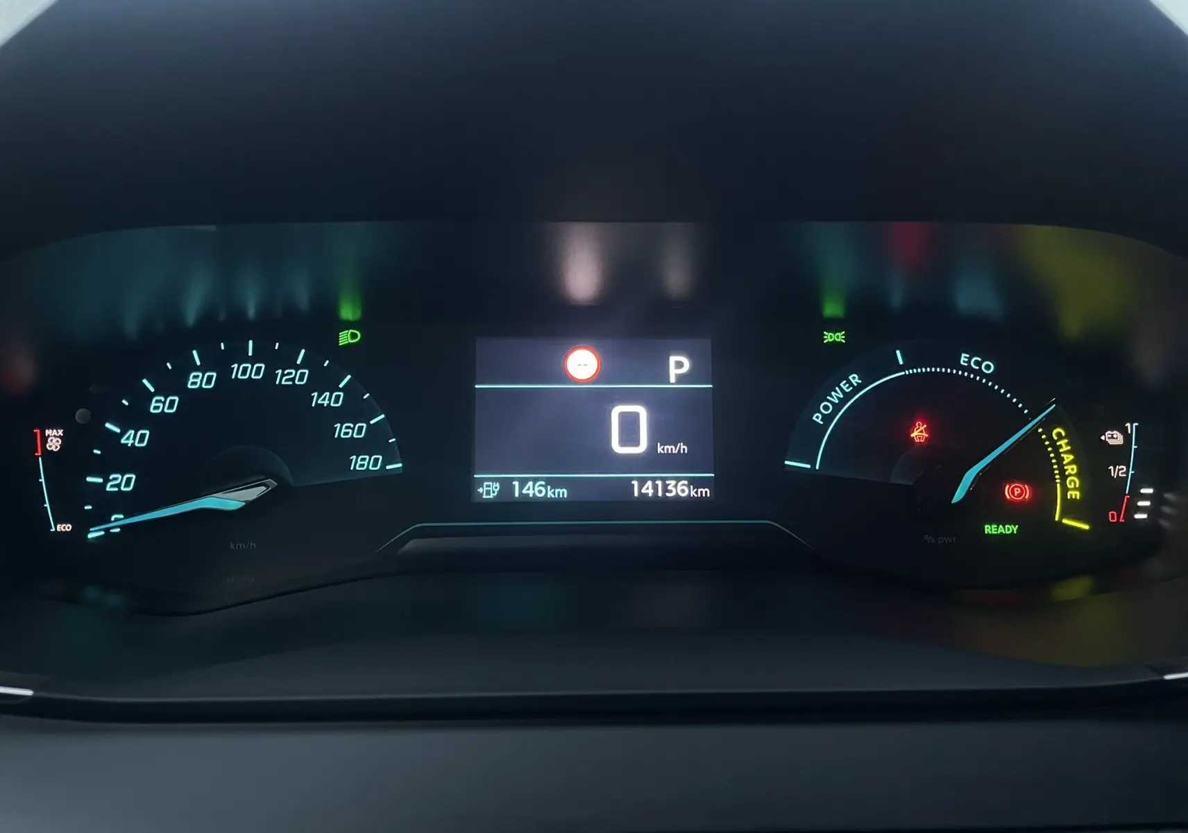 Tableau de bord numérique du Peugeot 208 électrique 2023 montrant vitesse à zéro et autonomie restante de 146 km.