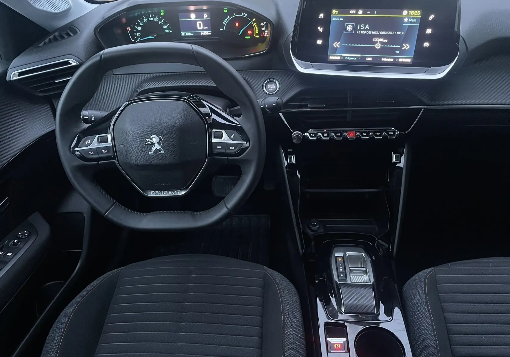 Vue intérieure avant du tableau de bord et volant de la Peugeot 208 II électrique 2023 avec écran tactile et commandes au volant.