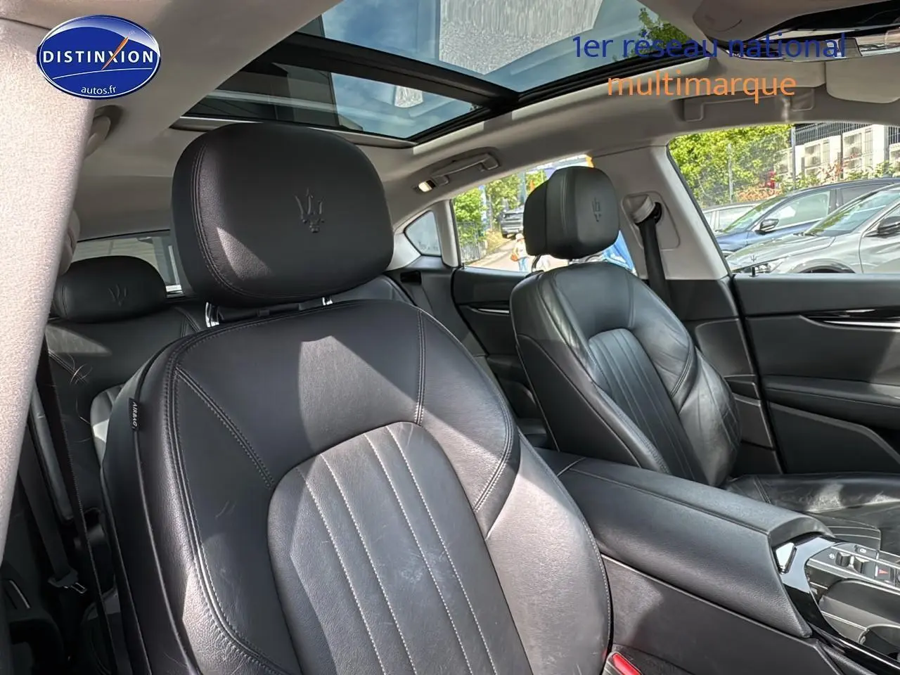 Intérieur cuir noir de Maserati Levante 2017 vu côté droit avec toit panoramique et accoudoir central.