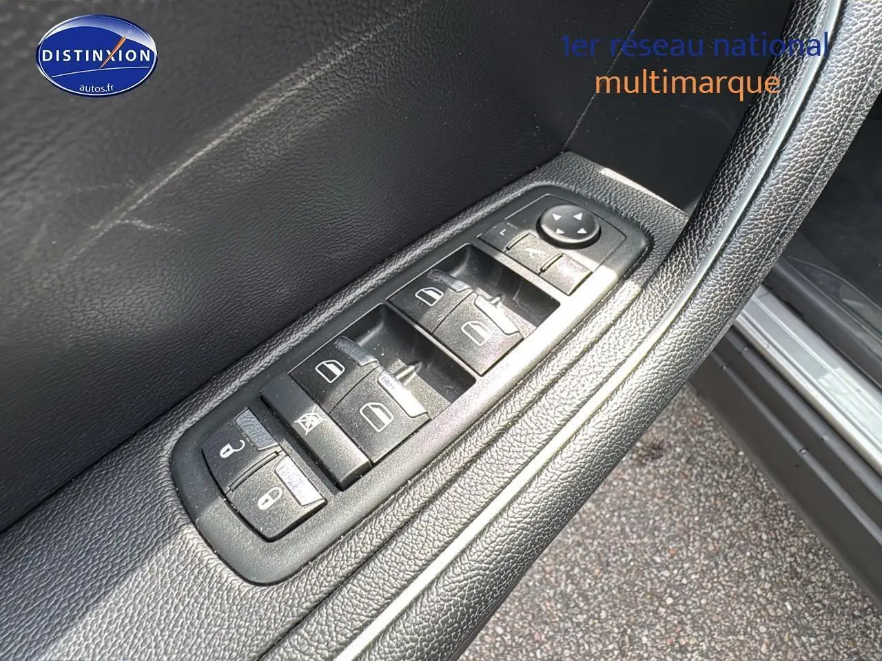 Gros plan sur les commandes des vitres et rétroviseurs côté gauche de la porte d'une Maserati Levante gris 2017.