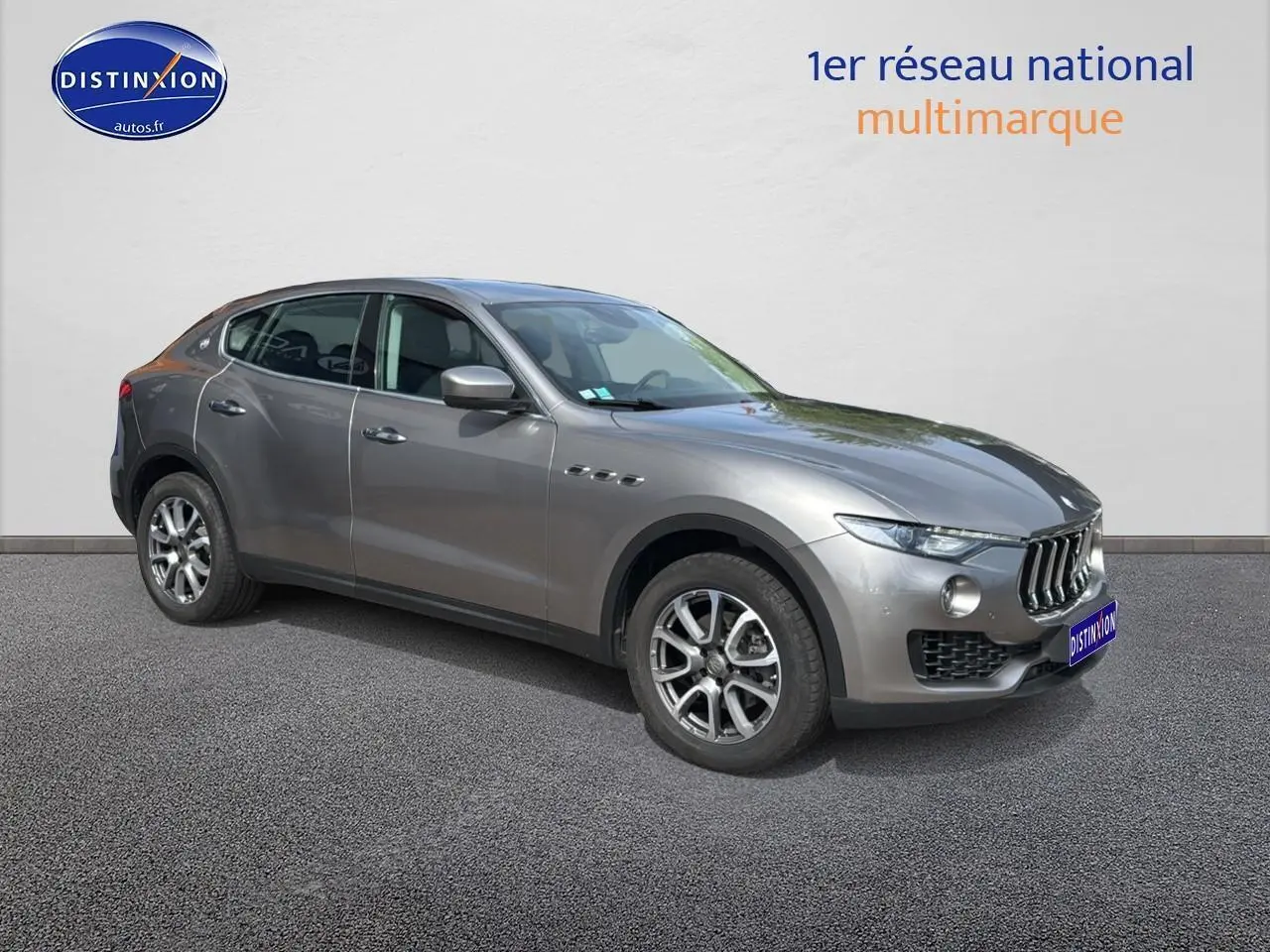 Maserati Levante gris en 3/4 avant droit, mettant en valeur sa calandre chromée et ses jantes alu distinctives.