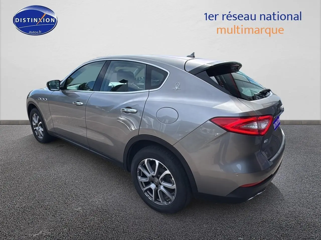 Vue 3/4 arrière droit d'un Maserati Levante gris métallisé avec jantes alu et feux arrière LED distinctifs.