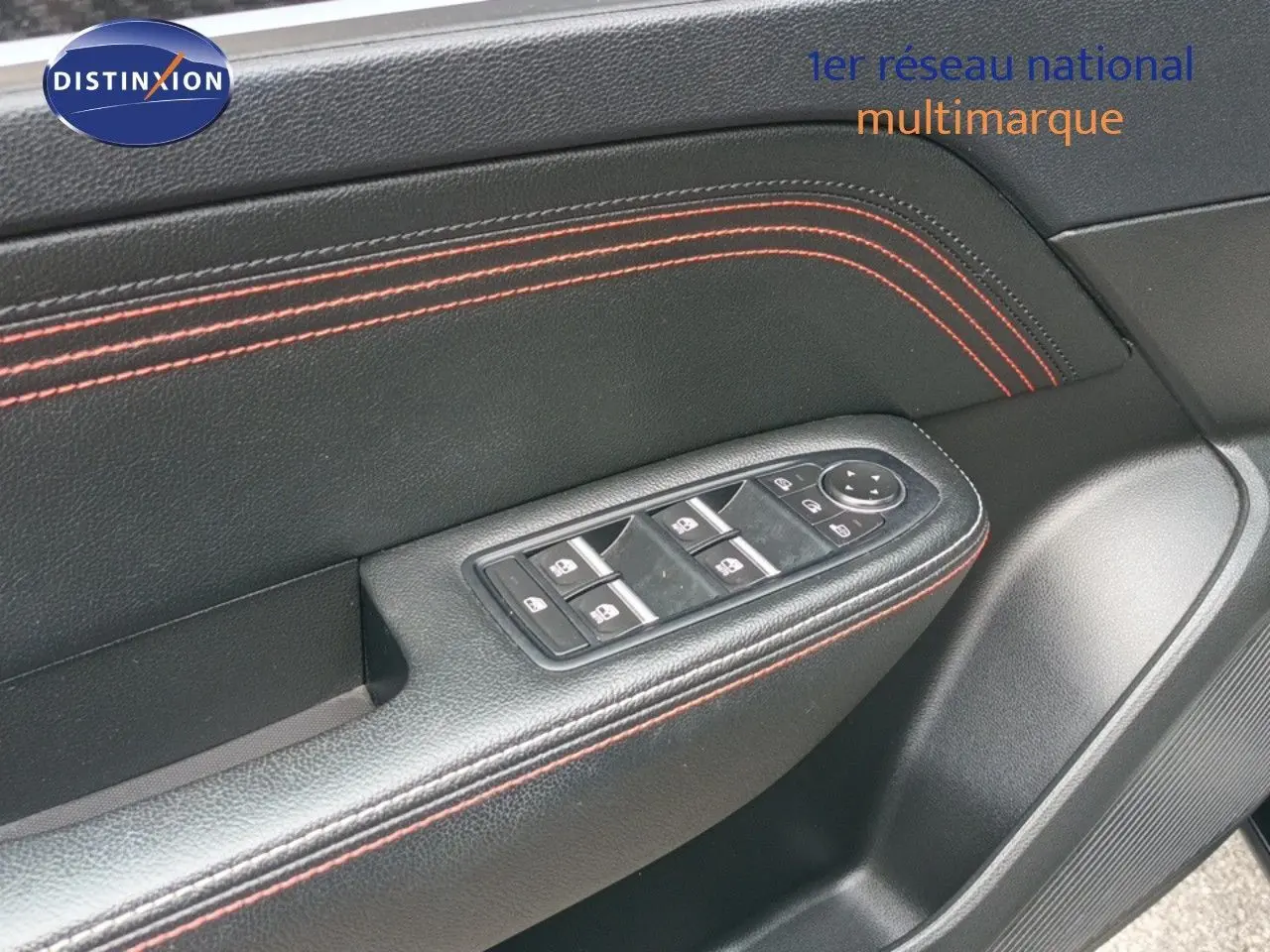 Gros plan sur la garniture noire avec surpiqûres rouges et commandes des vitres côté conducteur du Renault Arkana noir 2021.