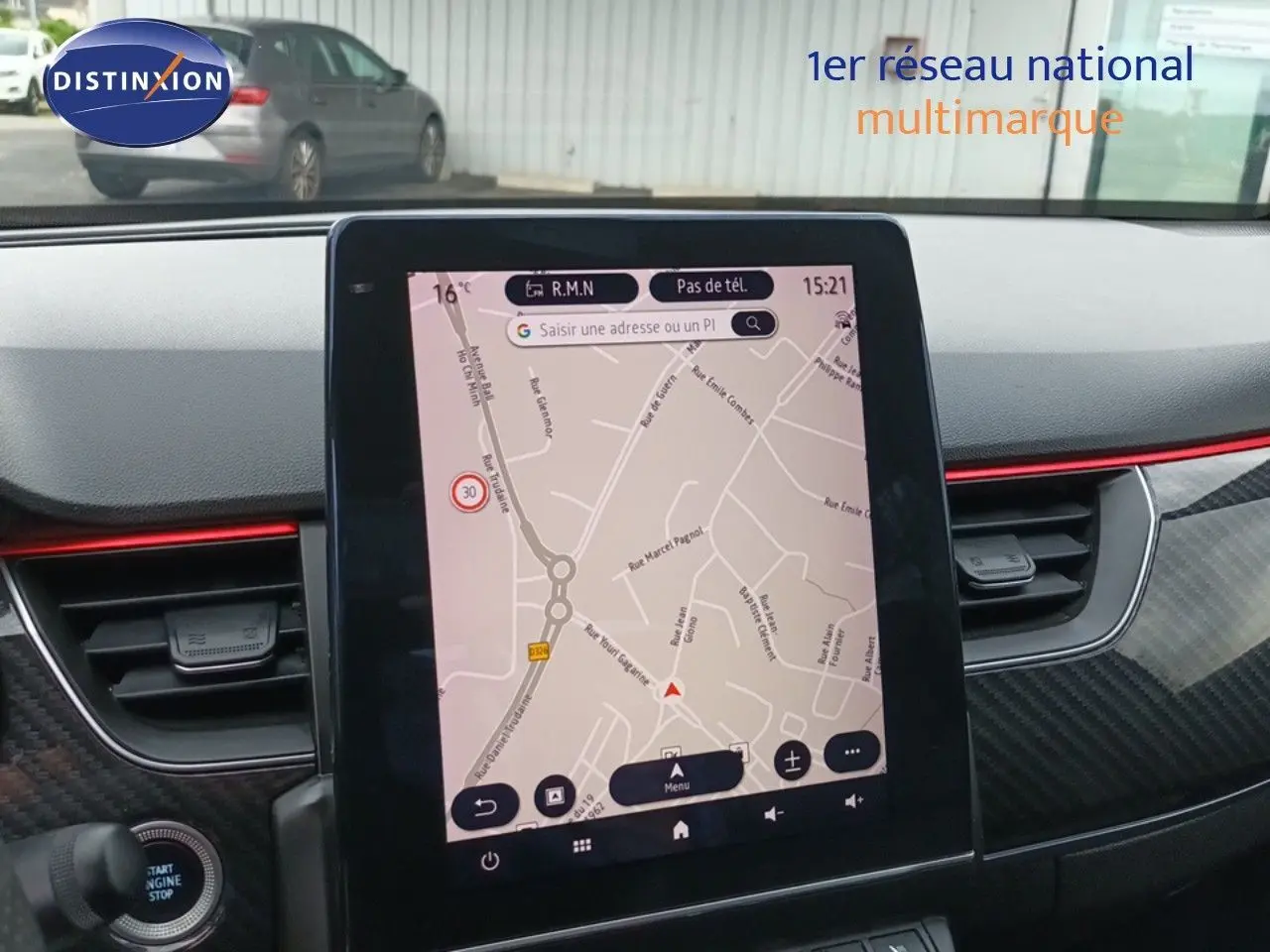 Écran tactile central affichant la navigation GPS dans l'habitacle du Renault Arkana noir, avec détails carbone et bande rouge.