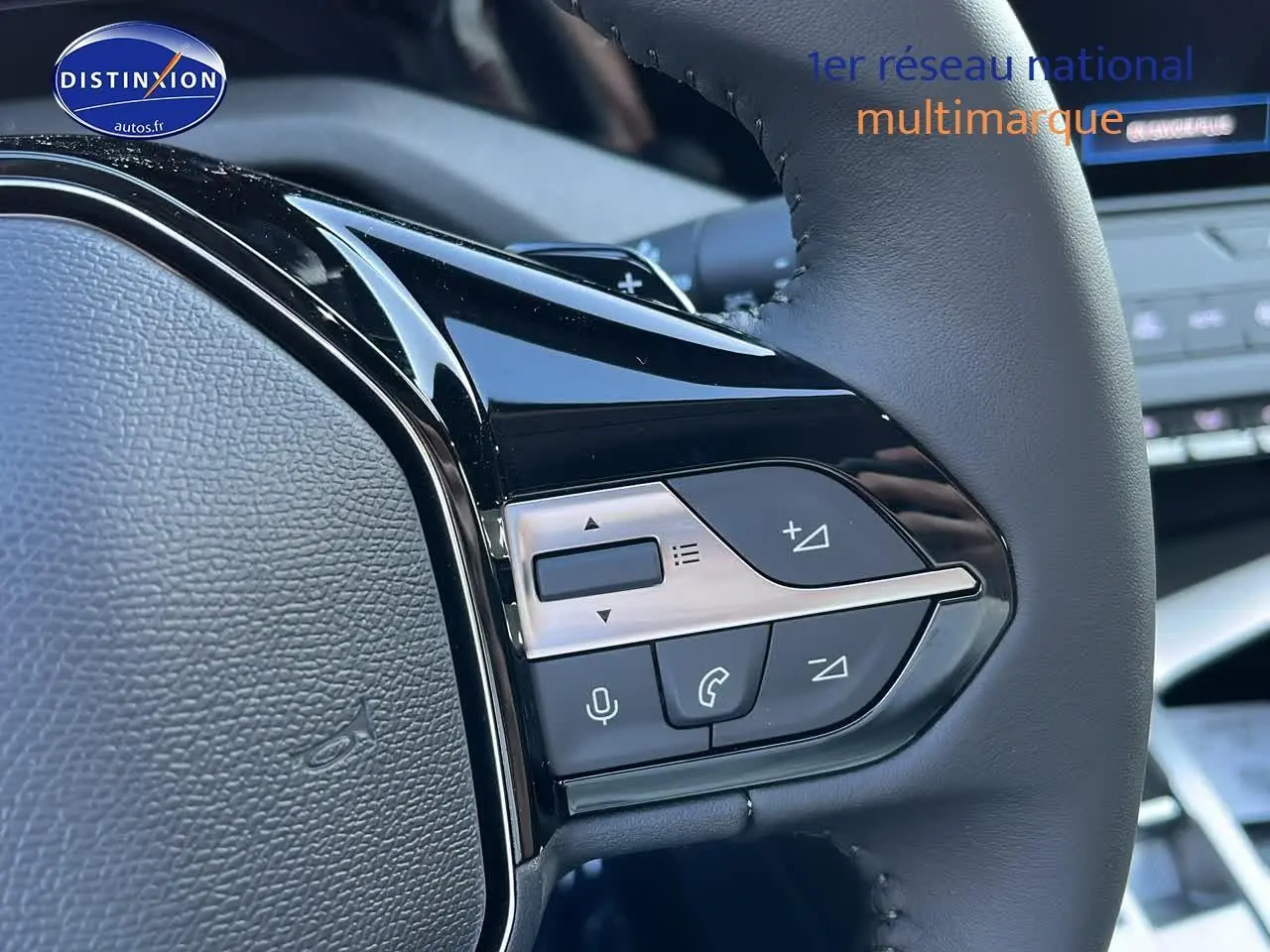 Gros plan sur les commandes multifonctions du volant cuir noir de la Peugeot 308 SW 2025 finition Allure.
