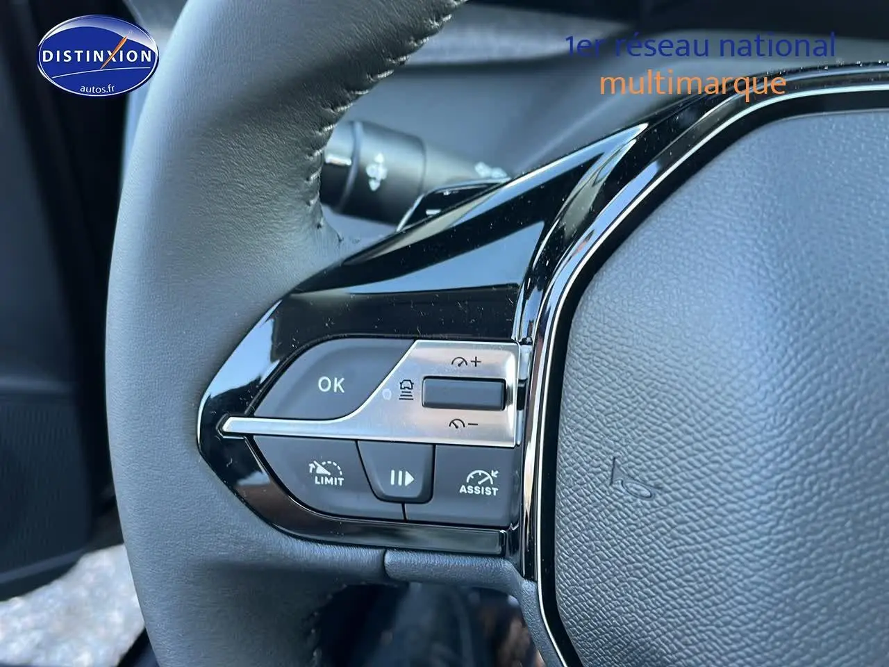 Gros plan sur les commandes au volant côté gauche d'une Peugeot 308 SW 2025 noir perle, soulignant les boutons multifonctions.