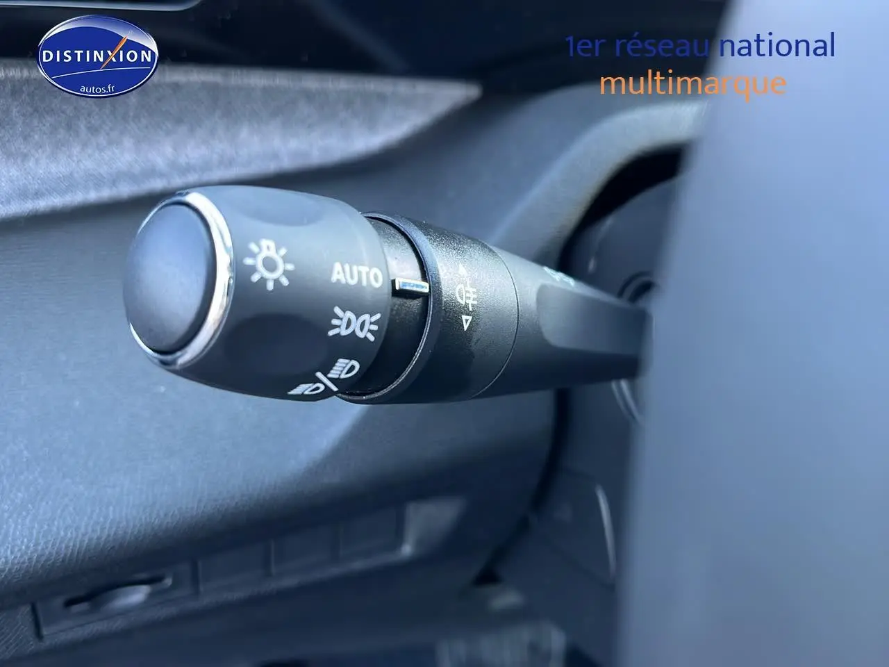 Gros plan sur la commande des phares automatique dans l'habitacle d'une Peugeot 308 SW noir perle 2025.