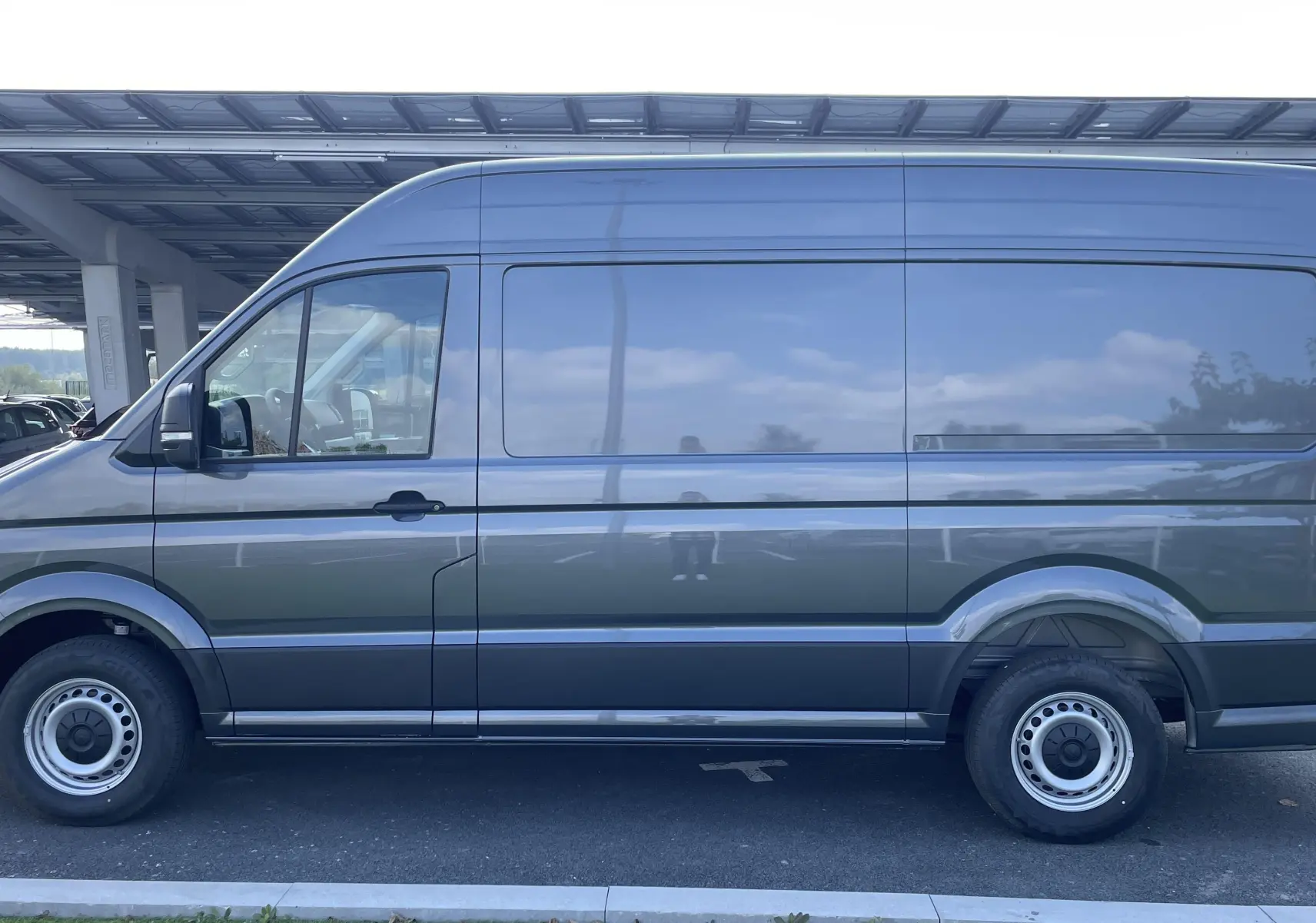 Profil latéral droit du Volkswagen Crafter Van gris Indium avec carrosserie haute et jantes acier simples.