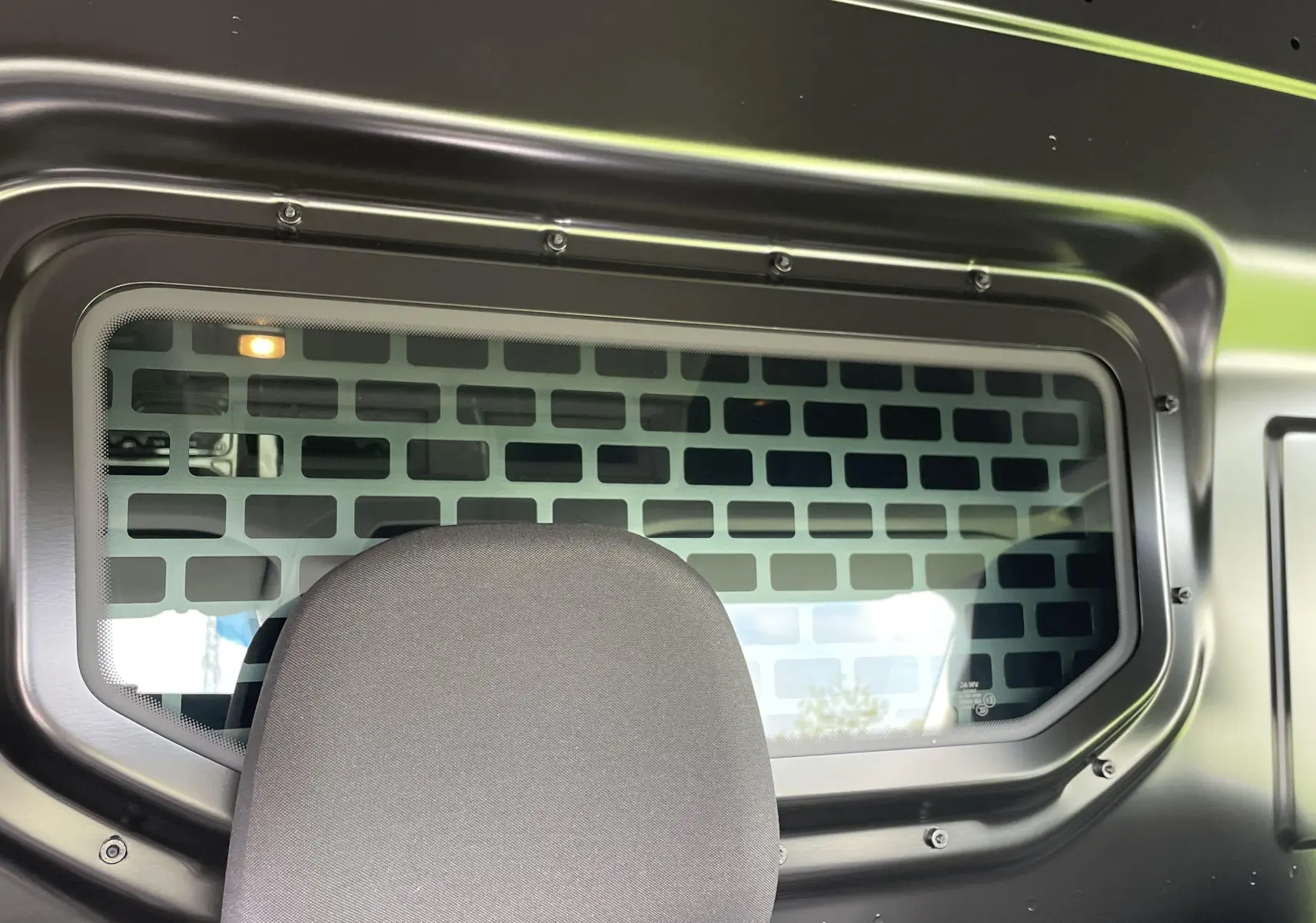 Vitre fixe avec grille de séparation entre cabine et chargement du Volkswagen Crafter Van gris Indium, vue intérieure arrière.