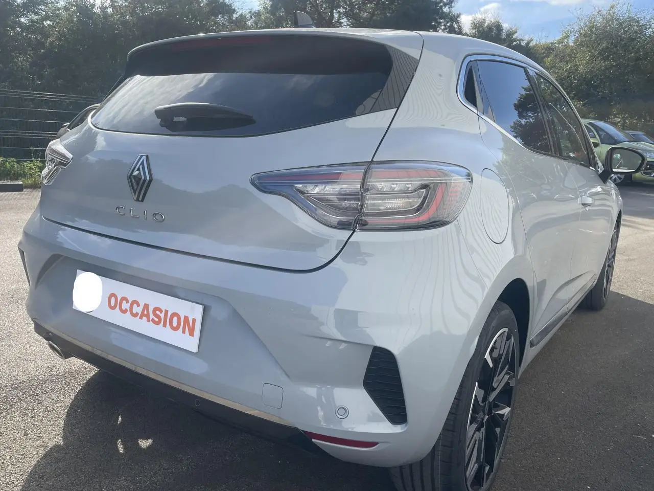 Vue 3/4 arrière droite d'une Renault Clio Gris Rafale avec jantes alliage 17 pouces et vitres surteintées.