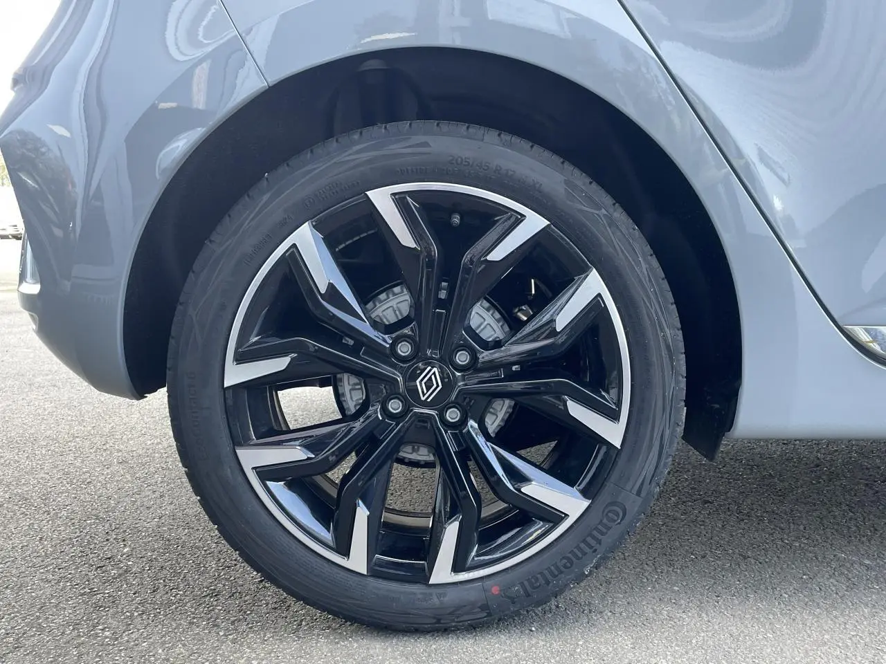 Gros plan sur la jante alliage diamantée 17 pouces noire et argent de la Renault Clio Gris Rafale côté arrière droit.