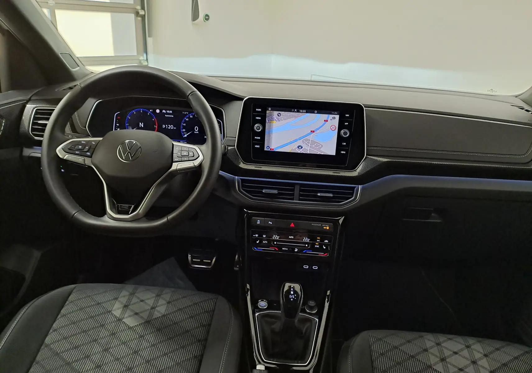 Vue intérieure du tableau de bord et volant du Volkswagen T-Cross 1.0 TSI R-Line Edition 2025, avec écran tactile et sellerie noire.