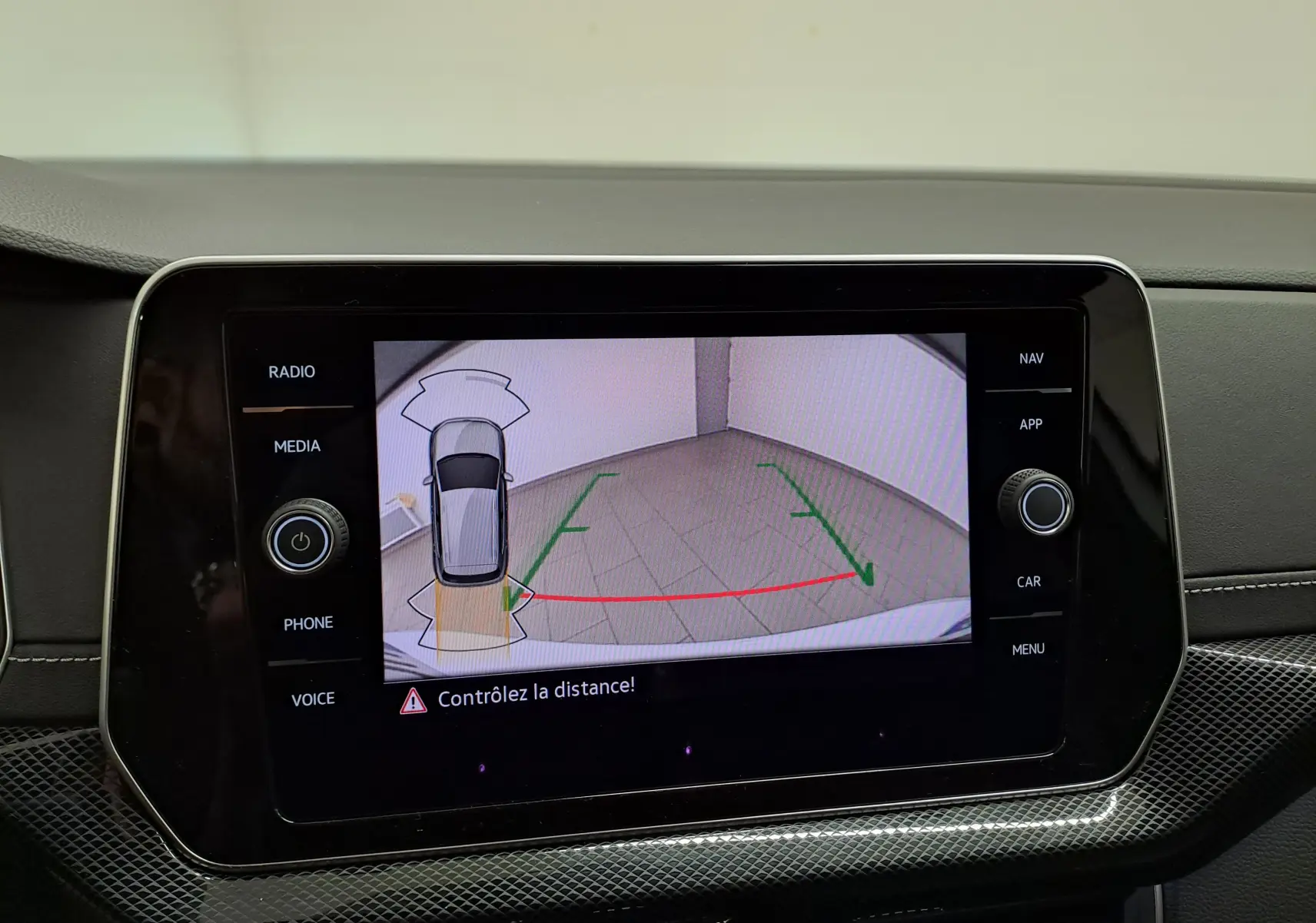 Écran central montrant la caméra de recul avec vue aérienne du Volkswagen T-Cross blanc pur R-Line Edition 2025.