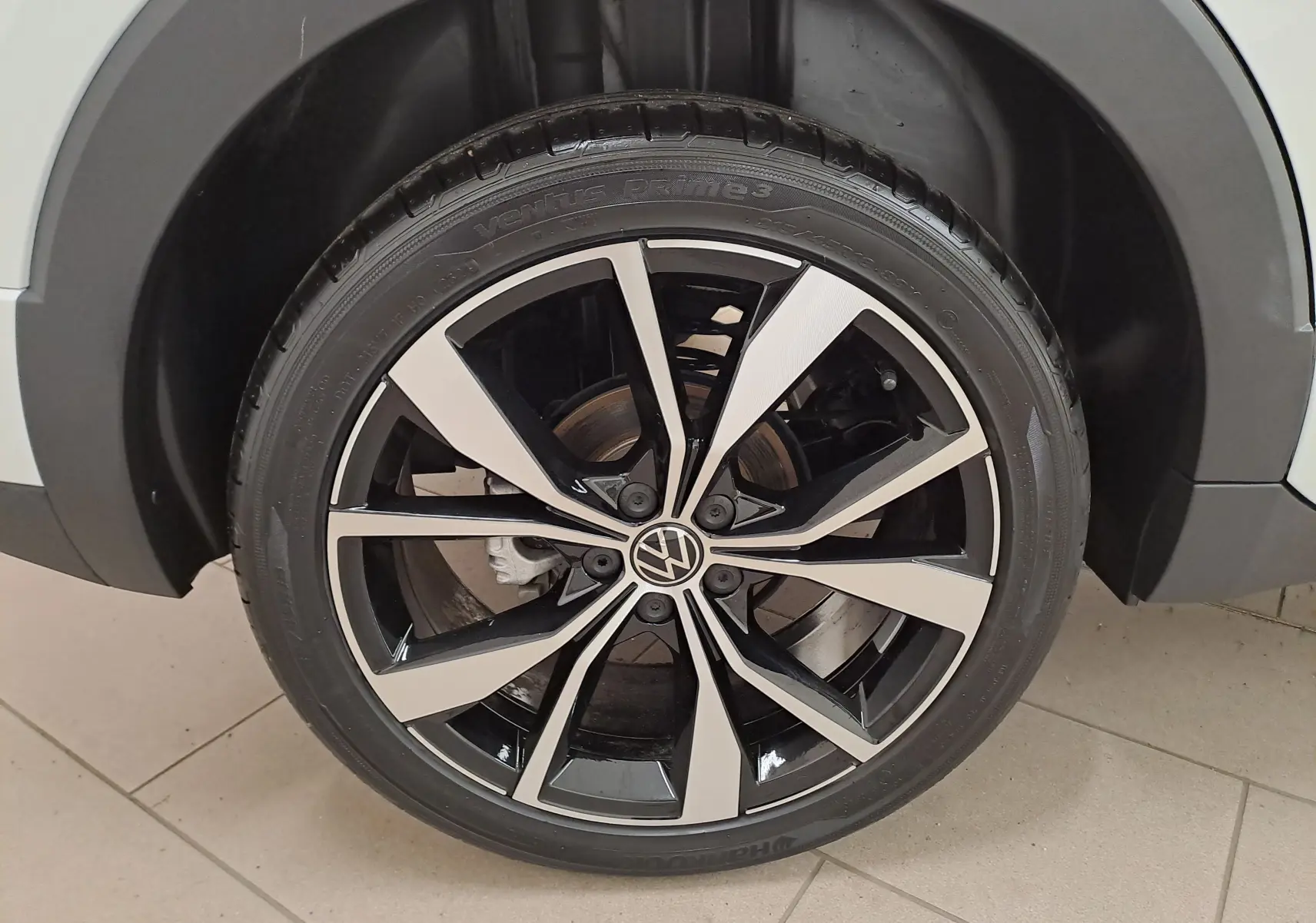 Volkswagen T-Cross blanc pur en vue 3/4 arrière droit, avec feux arrière LED et jantes alliage R-Line.