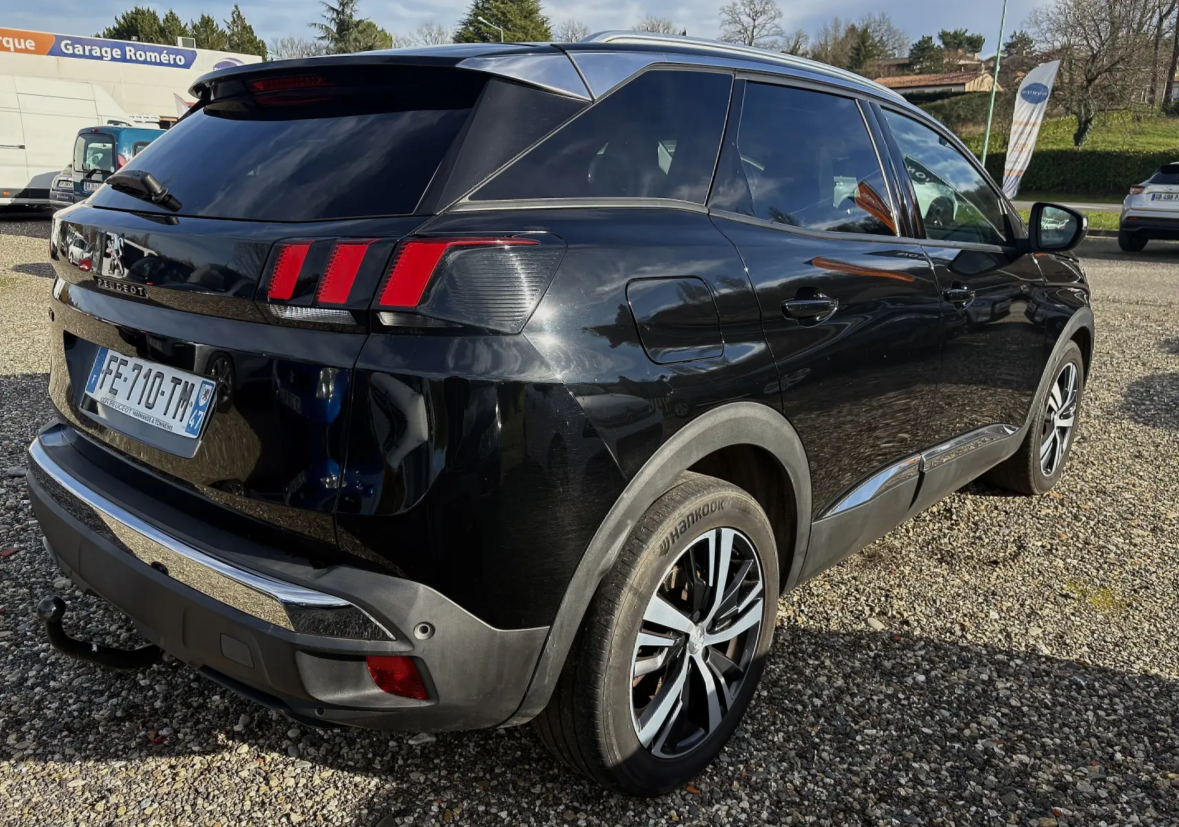 Vue 3/4 arrière droite d'un Peugeot 3008 noir 2019 avec feux arrière à griffes et attelage de remorque visible.