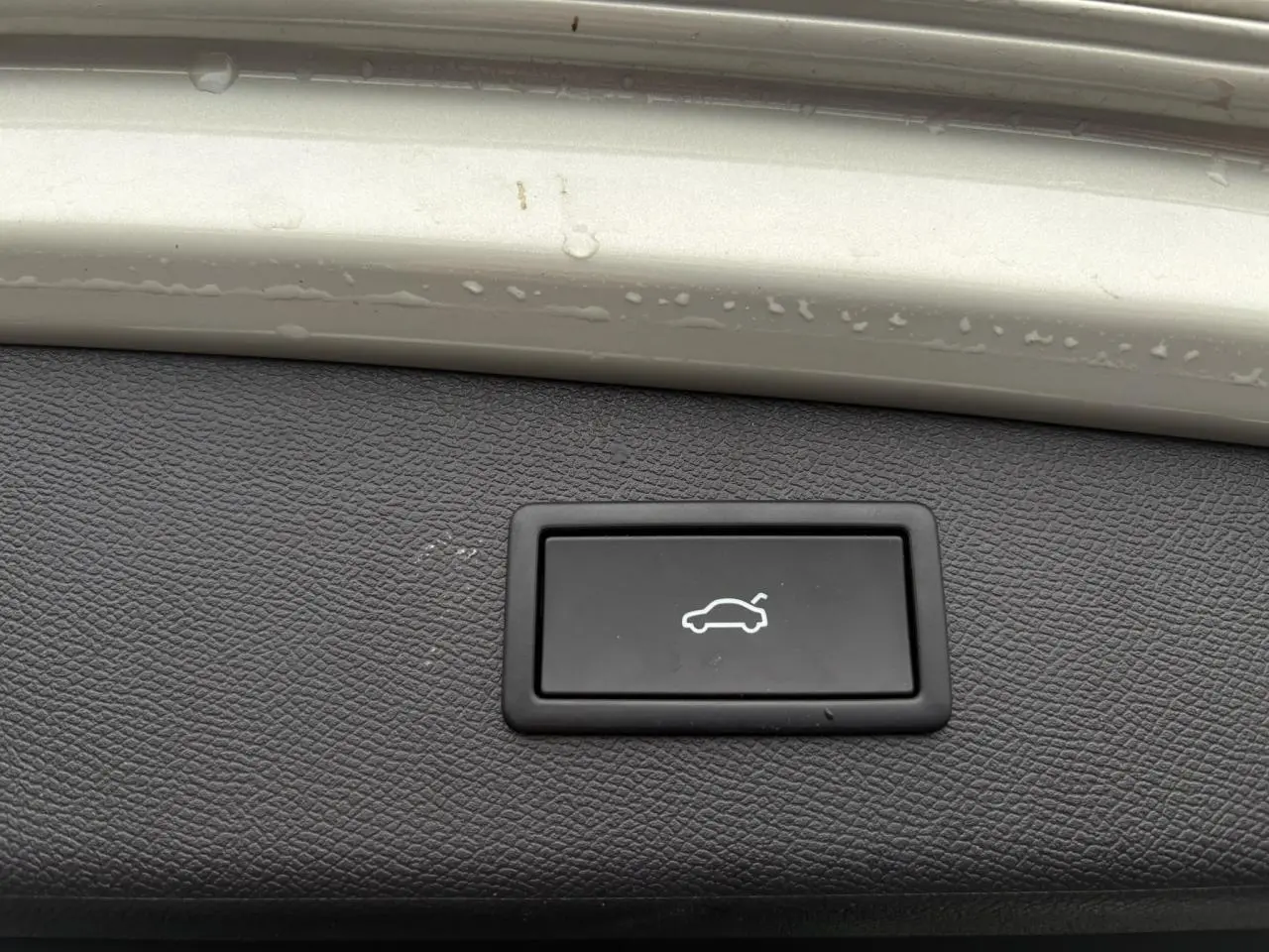 Bouton d'ouverture électrique du hayon sur panneau intérieur gris Taiga d'une CUPRA LEON ST 2025.