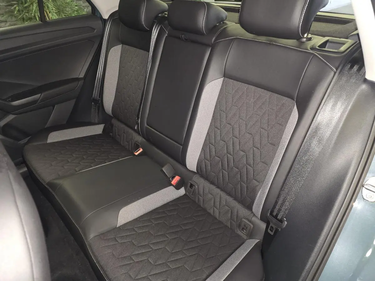 Vue intérieure de la banquette arrière du Volkswagen T-Roc 2025 avec sellerie tissu noir et gris à motifs géométriques.