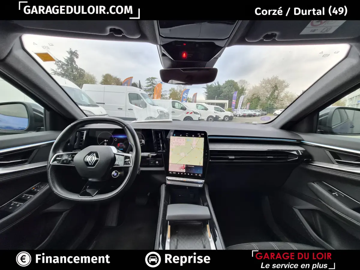 Vue intérieure avant du Renault Austral 2023 avec tableau de bord noir, écran tactile vertical et volant multifonctions.