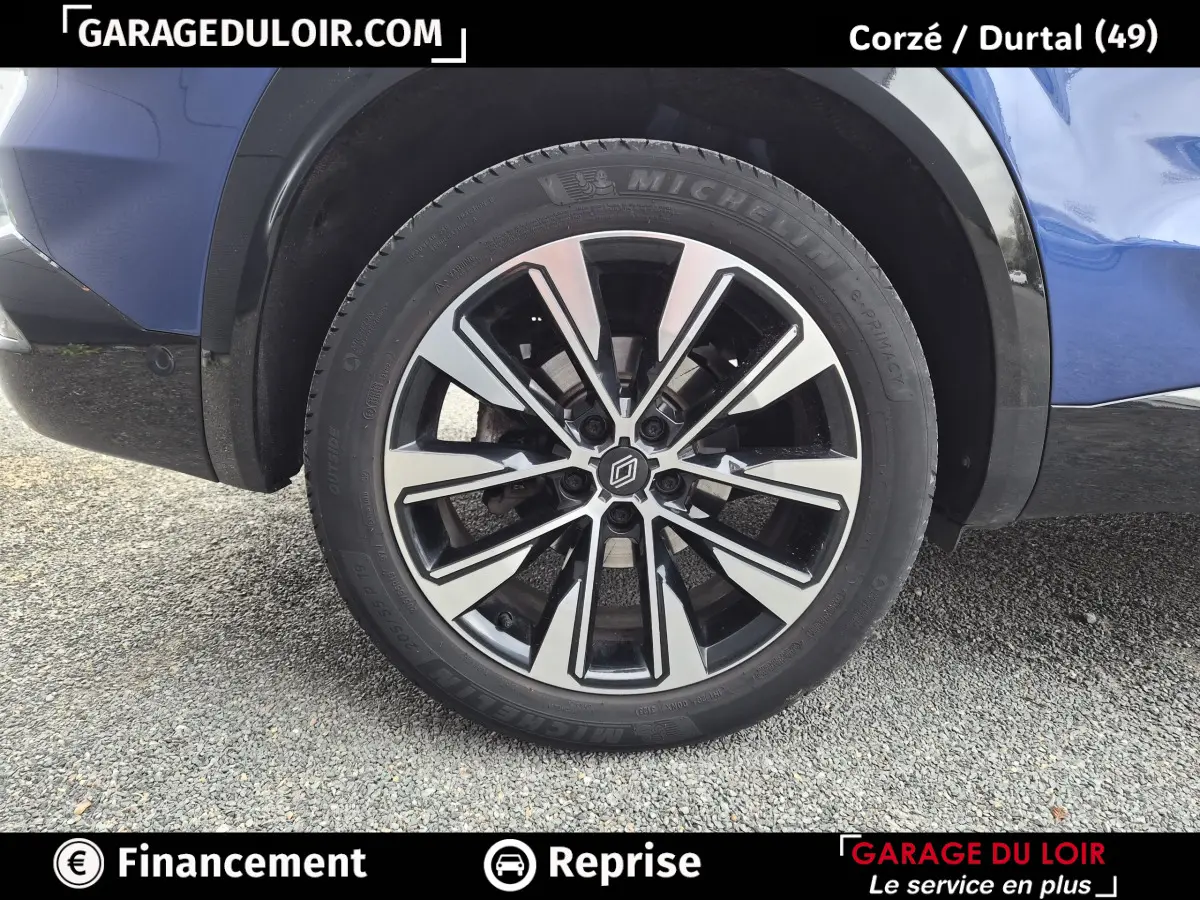 Gros plan sur la roue avant droite du Renault Austral bleu, avec jante alliage bicolore et pneu Michelin.