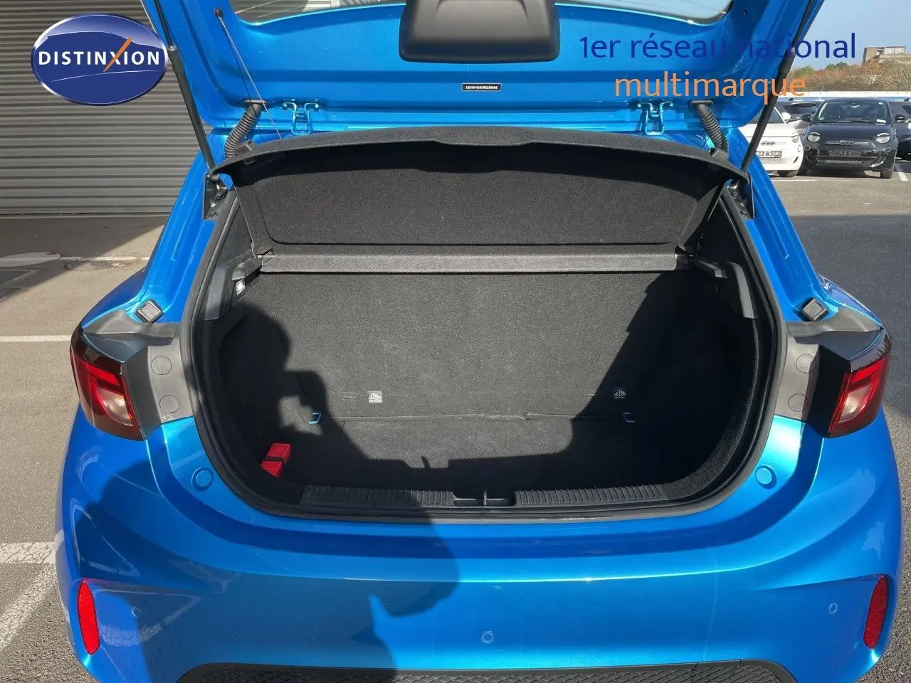 Coffre ouvert vu de l'arrière d'une MG3 1.5L Hybrid+ 195ch Comfort en bleu Como Metal, avec intérieur de coffre noir.
