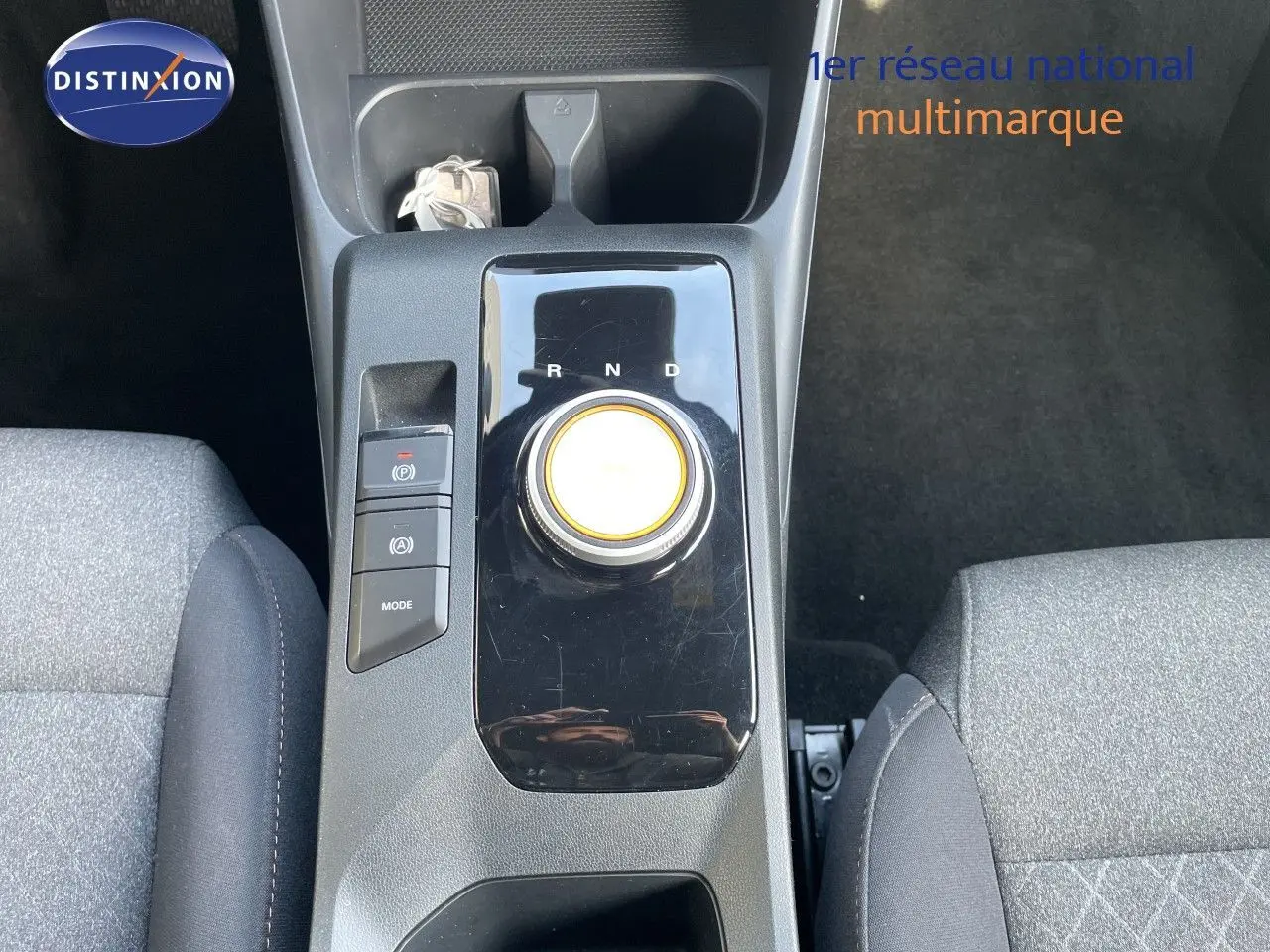 Vue plongeante sur la console centrale de la MG3 2025, avec molette de boîte auto et sièges tissu gris.