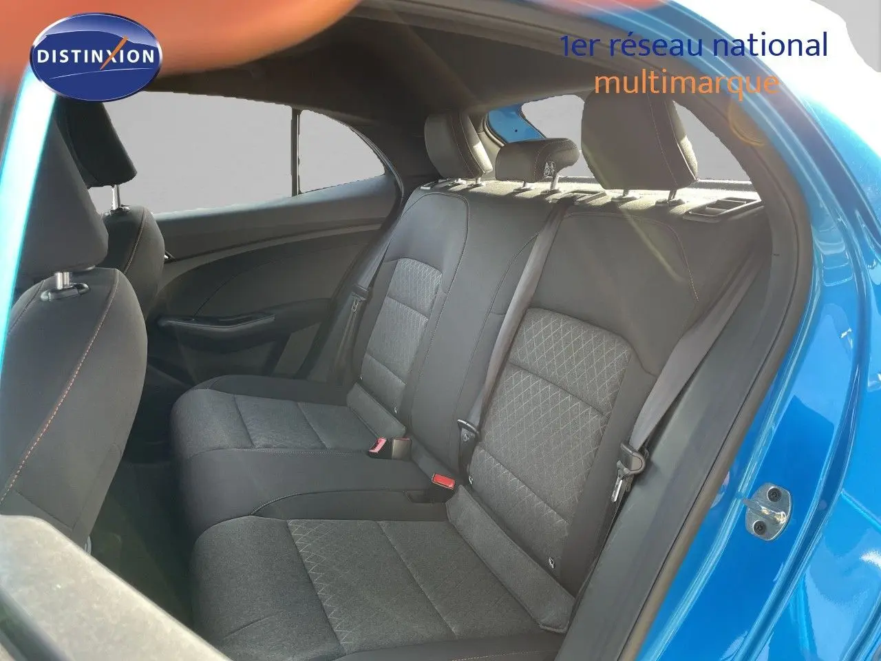 Vue intérieure côté droit sur les sièges arrière en tissu gris noir, avec portière ouverte et carrosserie bleu Como Metal visible.