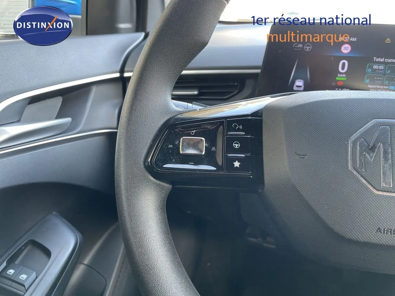 Vue rapprochée du volant noir de la MG3 2025, avec commandes intégrées et tableau de bord digital en arrière-plan.