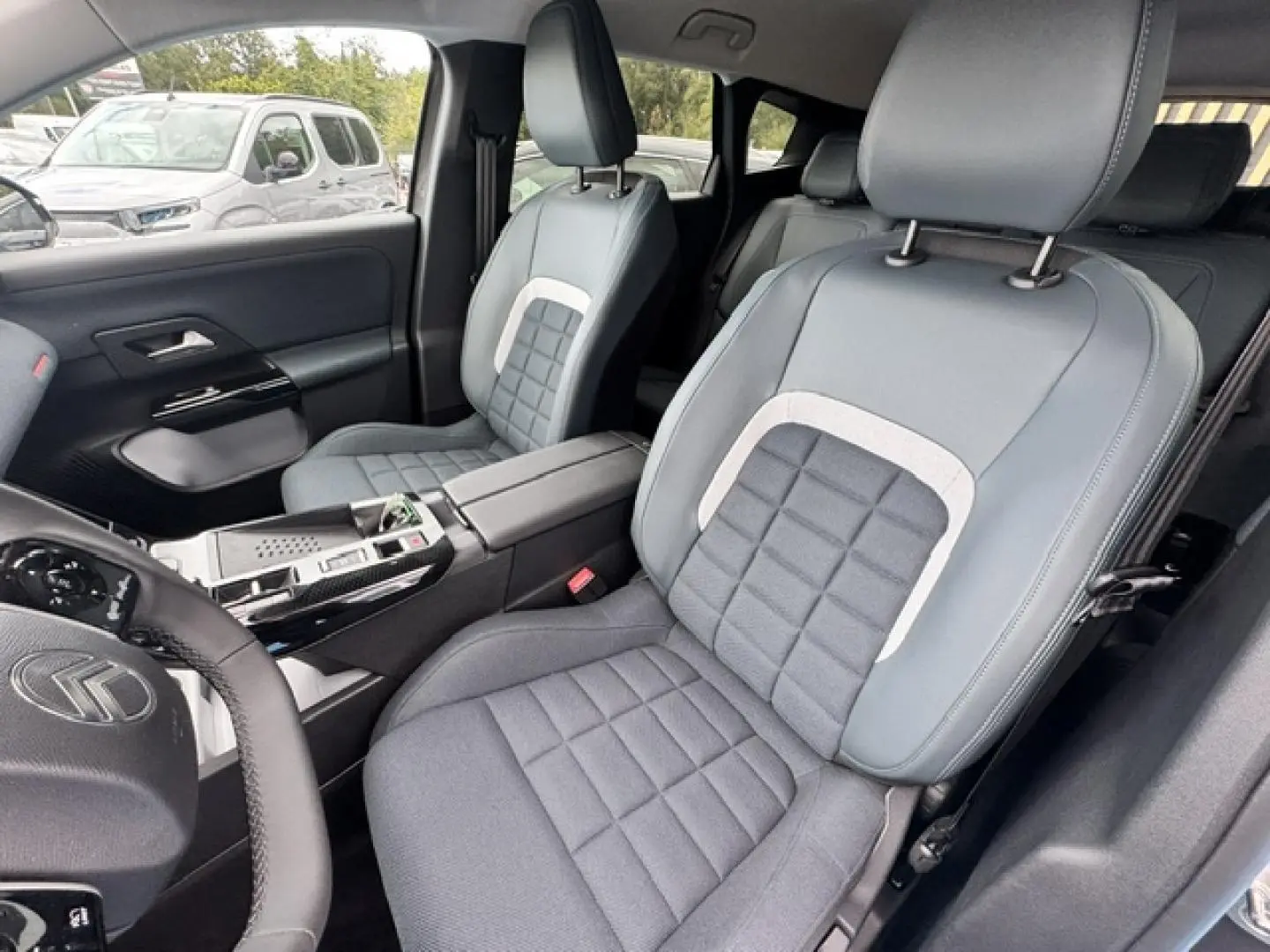 Vue intérieure côté conducteur du Citroën C5 Aircross 2026, sièges bi-matière gris avec accoudoir central.