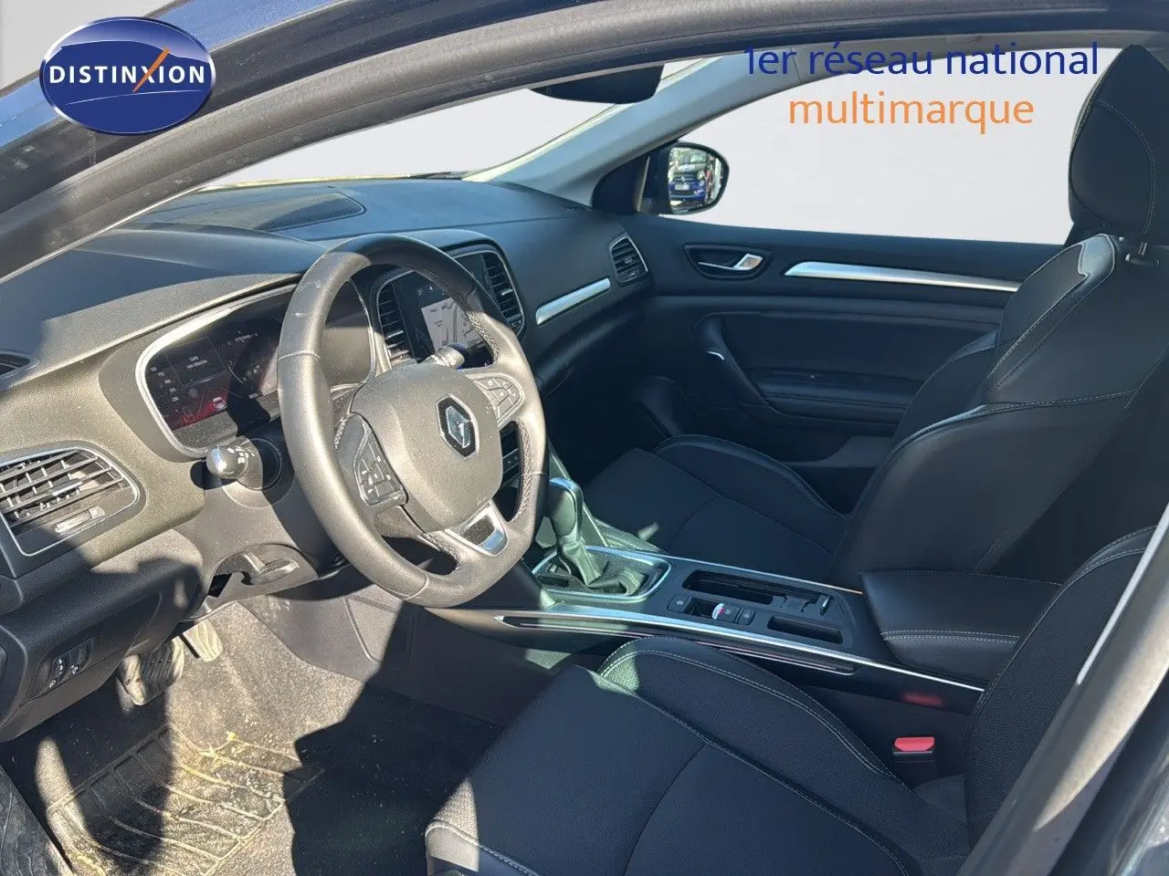 Intérieur avant de la Renault Mégane Break 2024 gris titanium, sièges noirs et tableau de bord moderne avec volant multifonction.