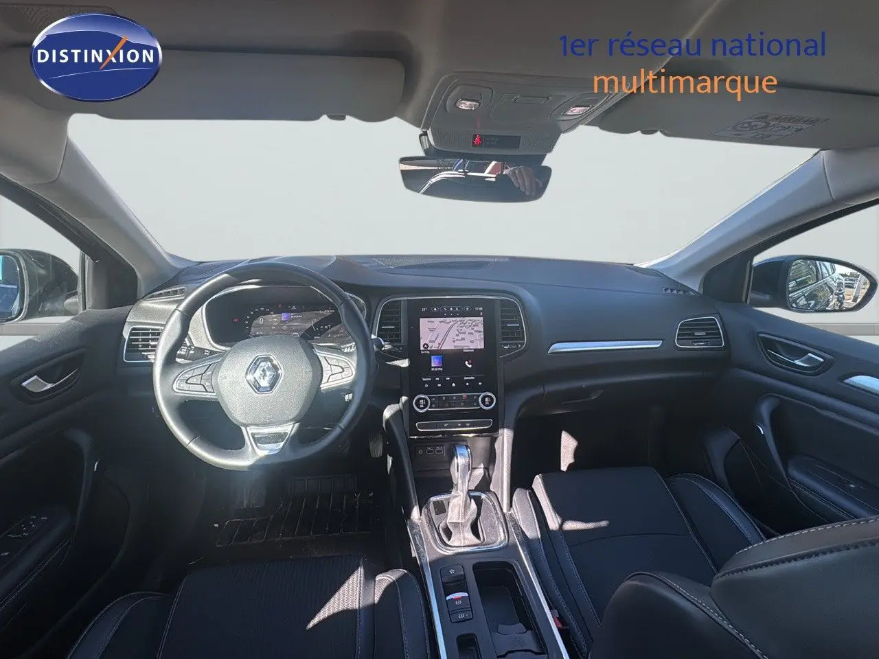 Vue intérieure avant de la Renault Mégane Break 2024 gris titanium, avec tableau de bord numérique et écran tactile central.