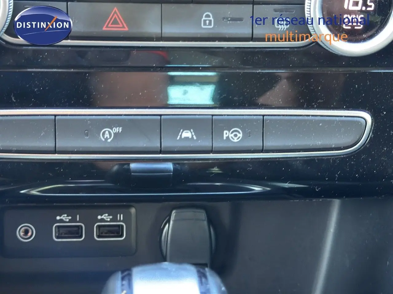 Gros plan sur la console centrale de la Renault Mégane Break gris titanium, montrant les ports USB et commandes d'assistance.