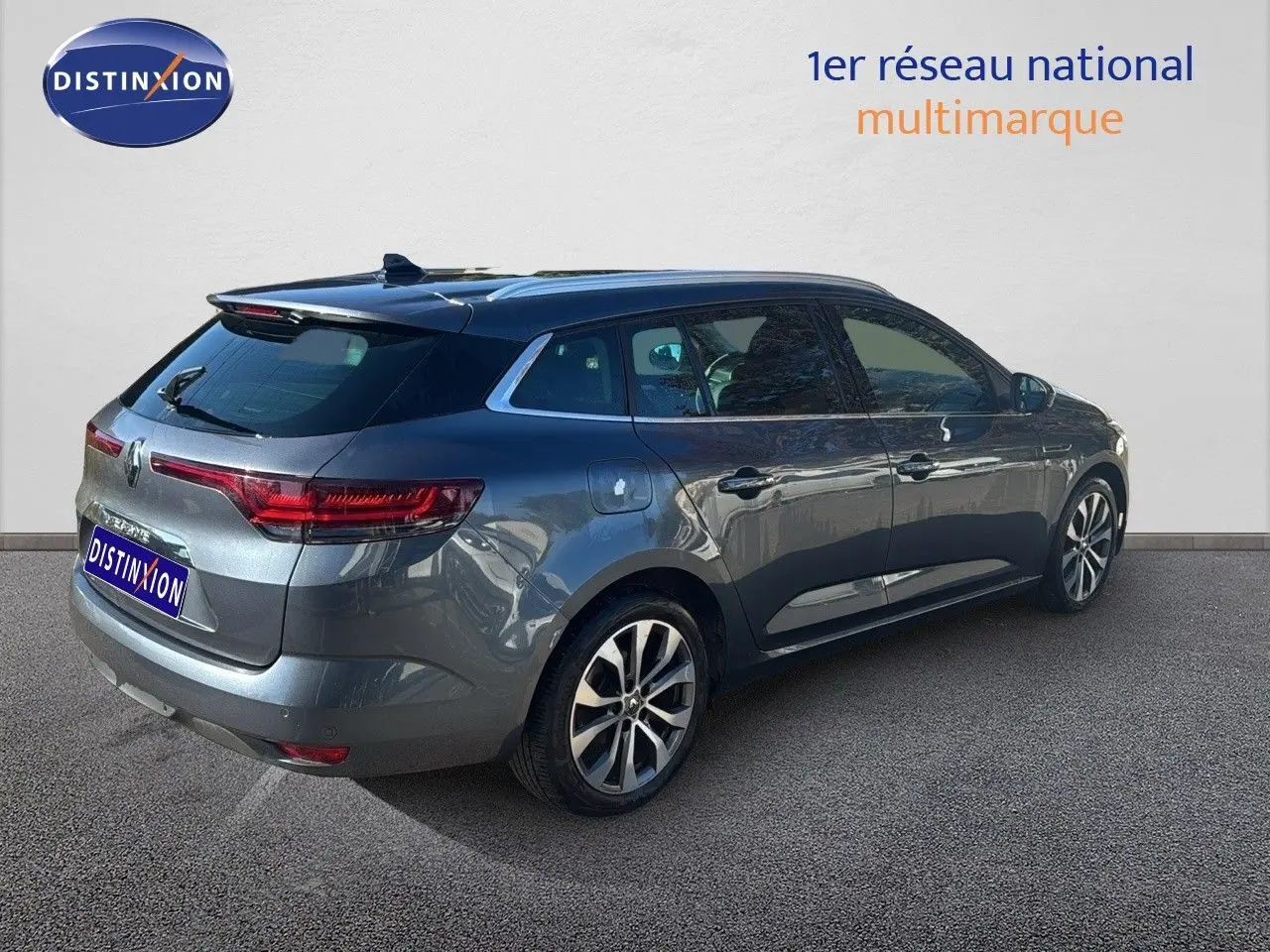 Vue 3/4 arrière droite d'une Renault Mégane Break gris titanium métal avec jantes alliage bicolores.