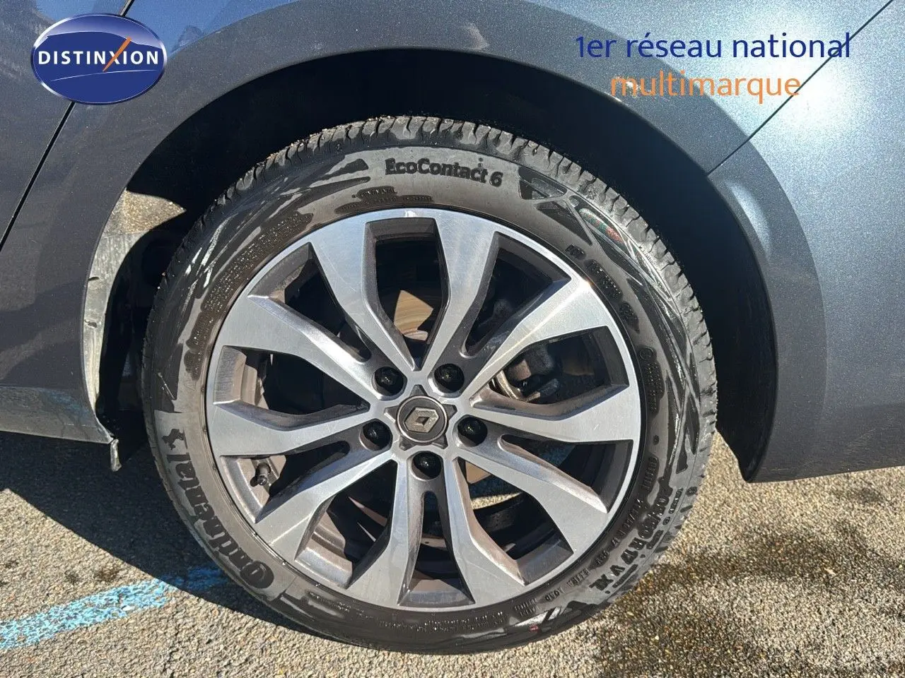 Gros plan sur la roue avant droite d'une Renault Mégane Break gris titanium avec jante alliage à dix branches.