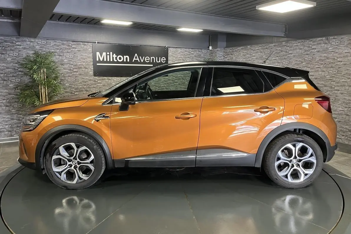 Profil droit du Renault Captur 1.6 E-Tech hybride rechargeable 2022 orange avec toit noir et jantes alliage 18 pouces.