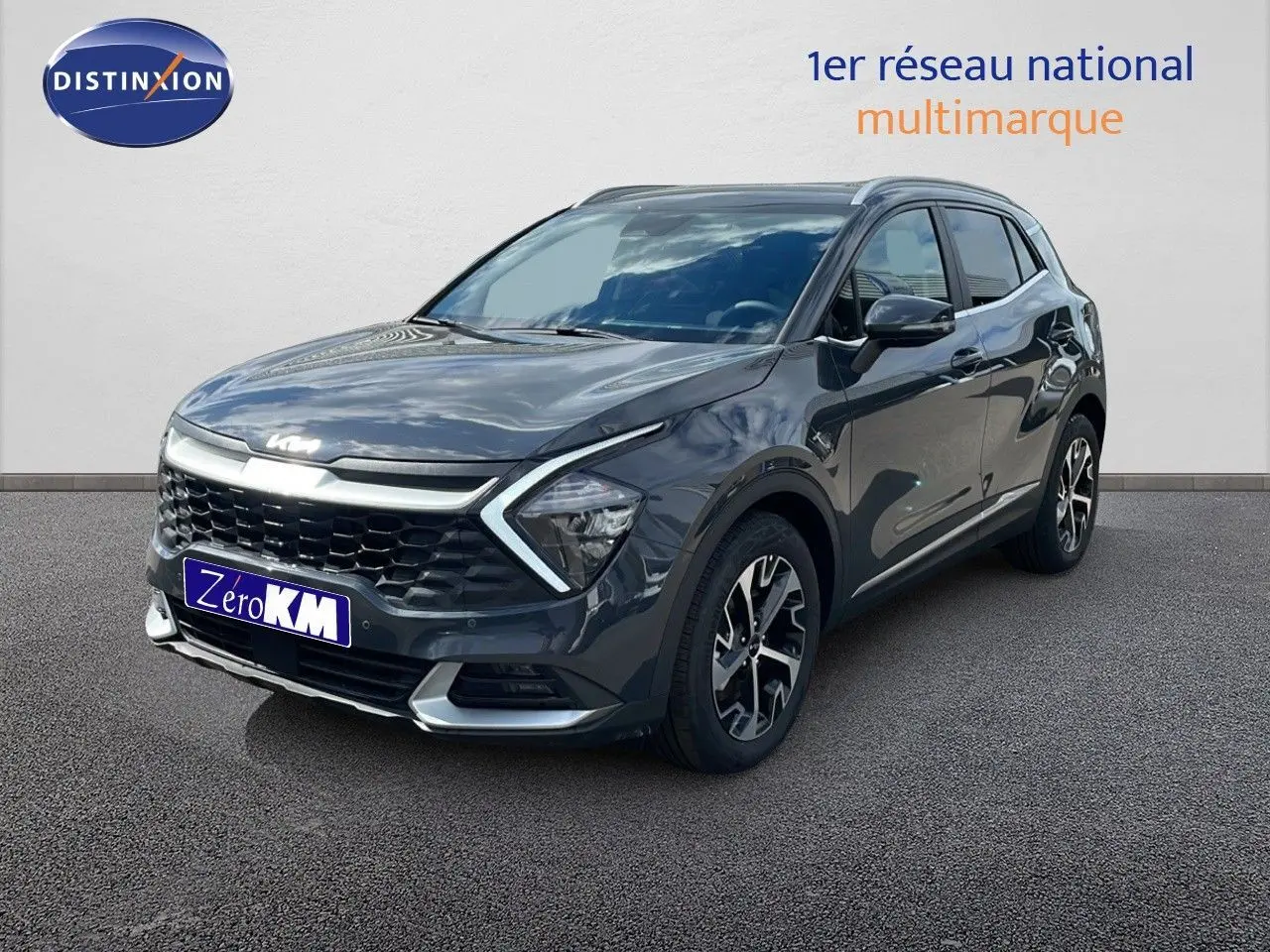 KIA Sportage gris foncé métal en 3/4 avant droit, avec calandre noire et jantes bi-ton distinctives.