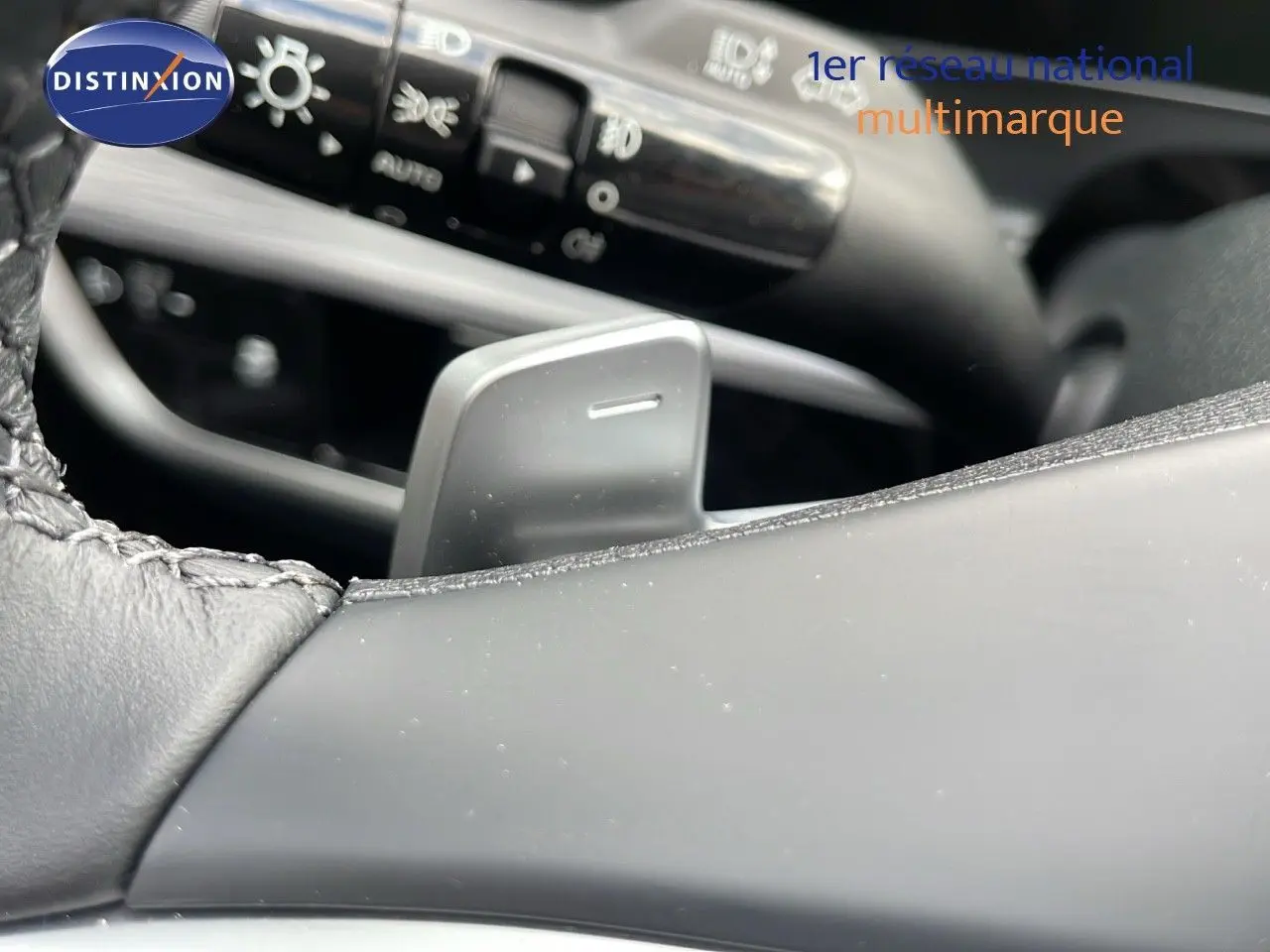 Gros plan sur la palette de changement de vitesse côté droit du volant cuir du Kia Sportage gris foncé 2025.