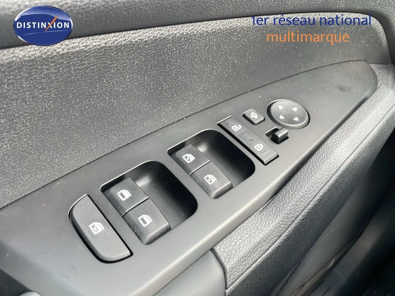 Gros plan sur les commandes des vitres et rétroviseurs côté gauche d'un Kia Sportage gris foncé 2025.